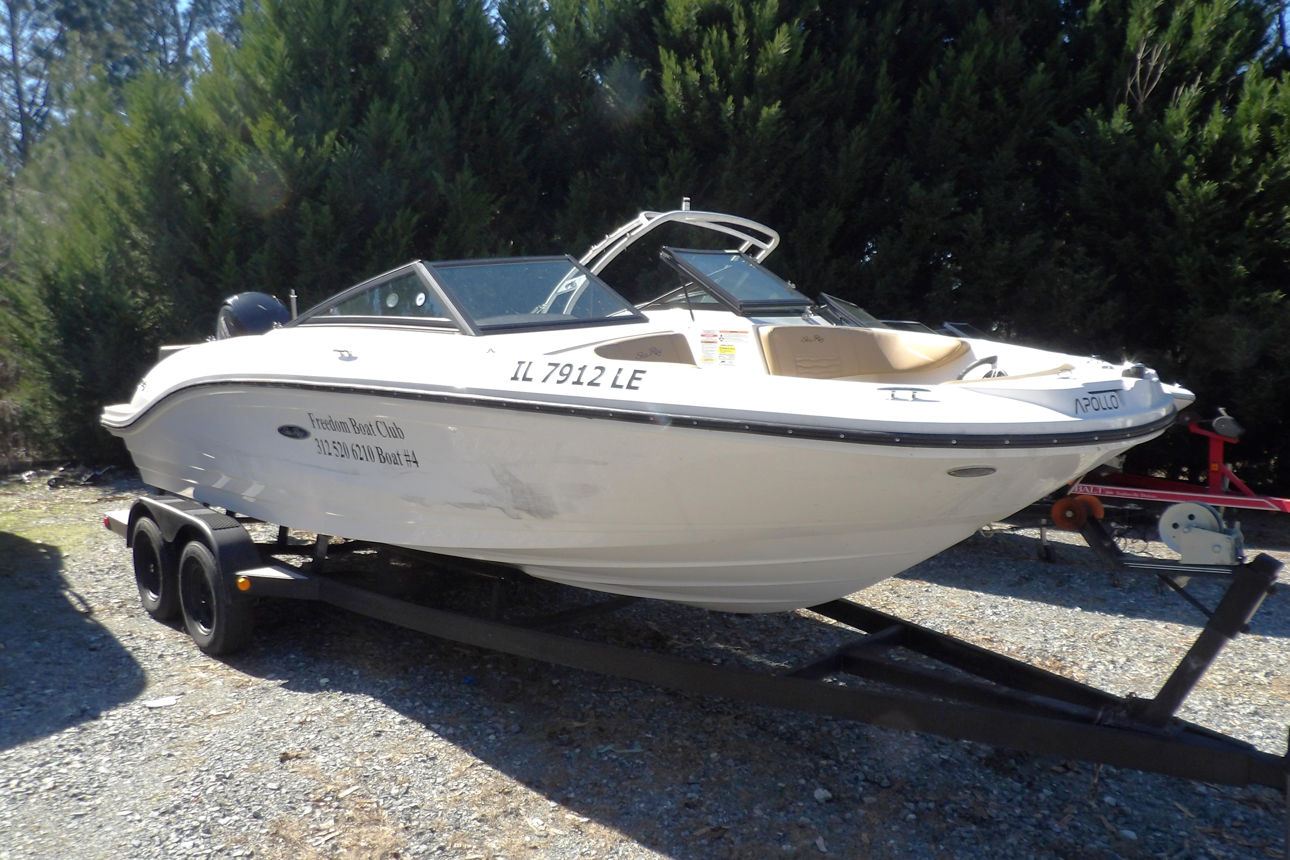 2023 Searay 210 SPO boat on trailer, parked outdoors with trees in background.
