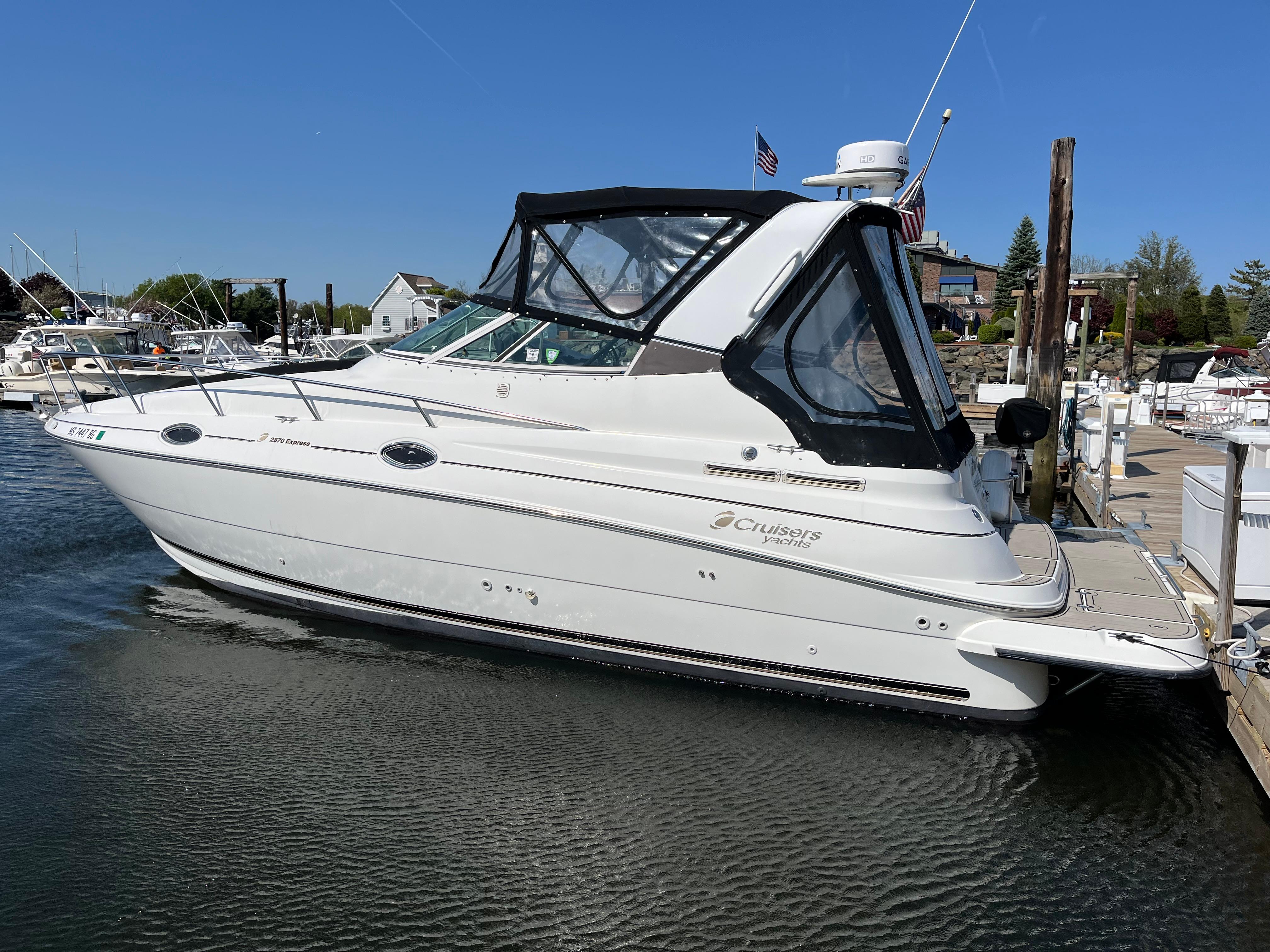 2001 Cruisers Yachts 2870 Express docked at marina, side view.