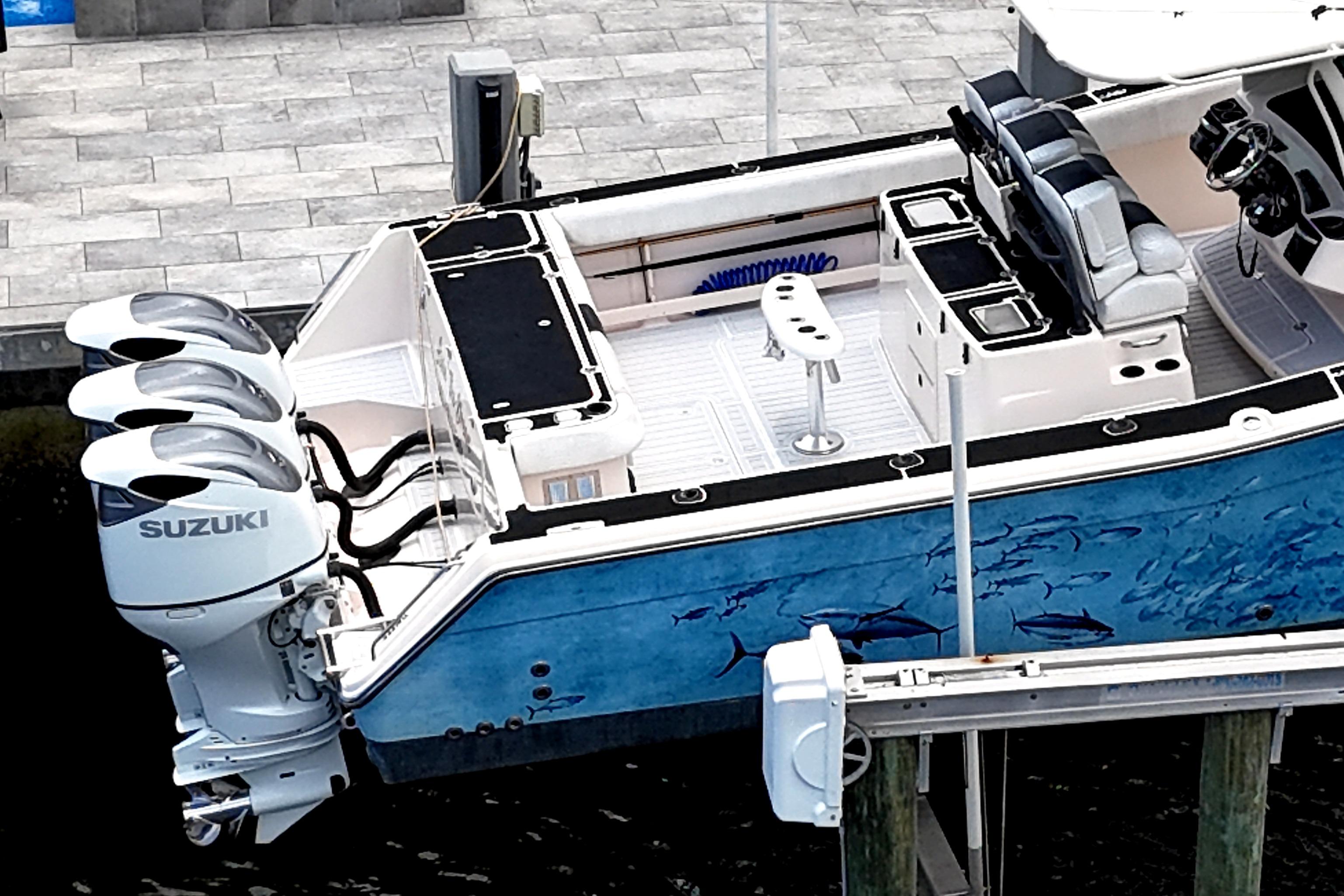 2010 Grady-White Canyon 366 boat with Suzuki engines, docked, featuring marine-themed artwork.
