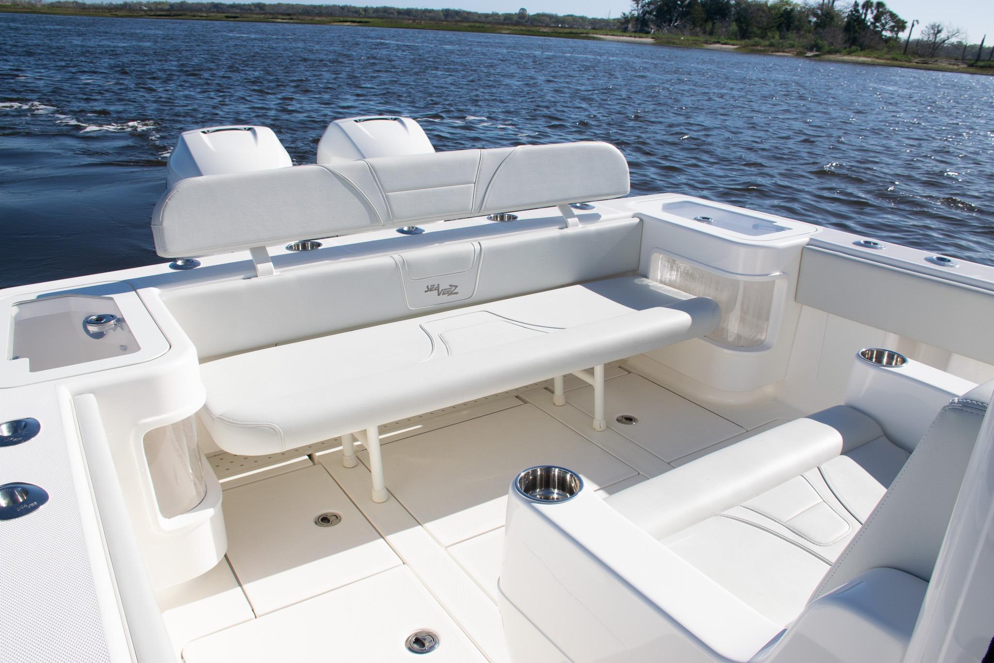 2022 SeaVee 322Z boat interior with white seating and cup holders on a calm lake.
