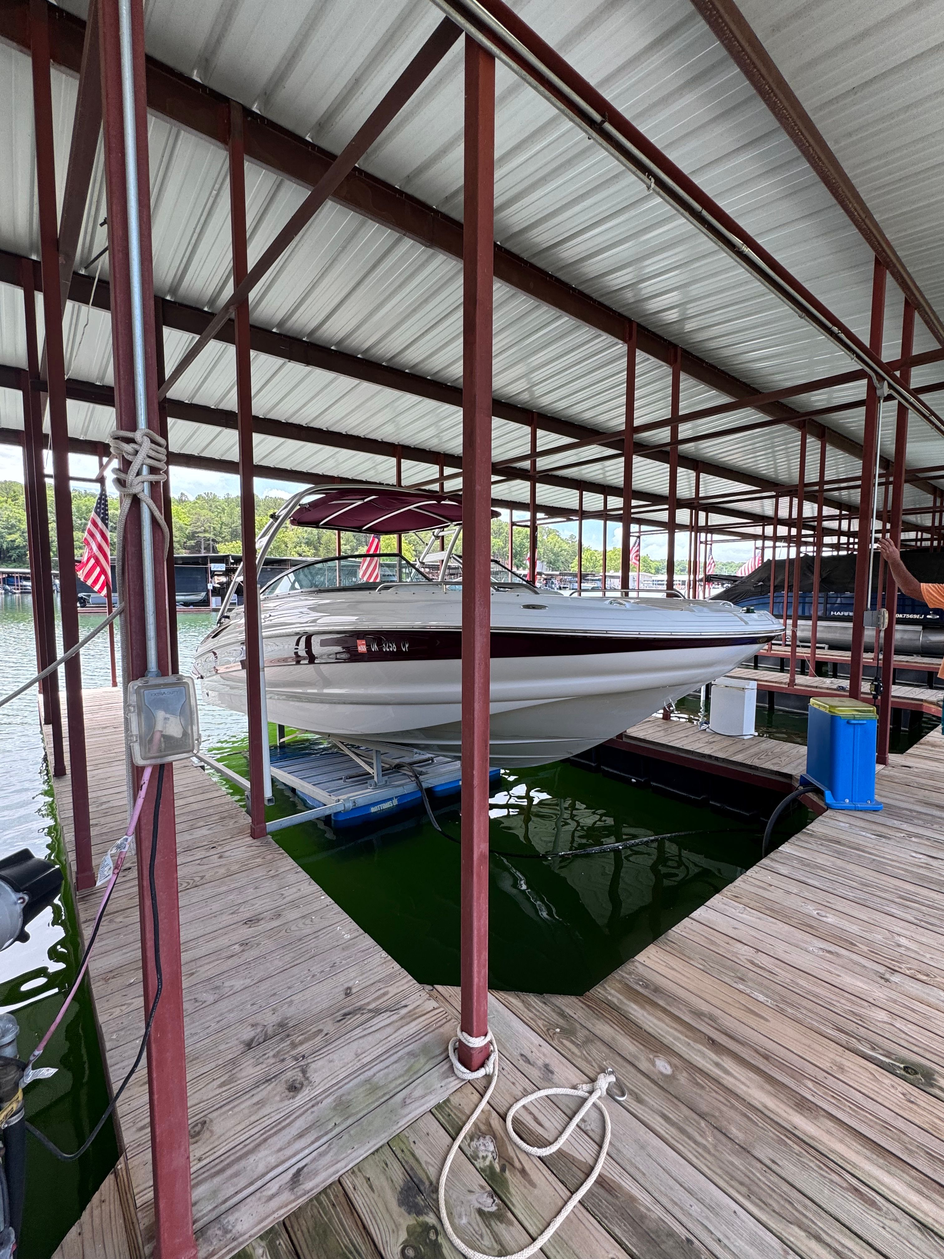 A 2008 Crownline 252EX boat is docked under a covered structure.