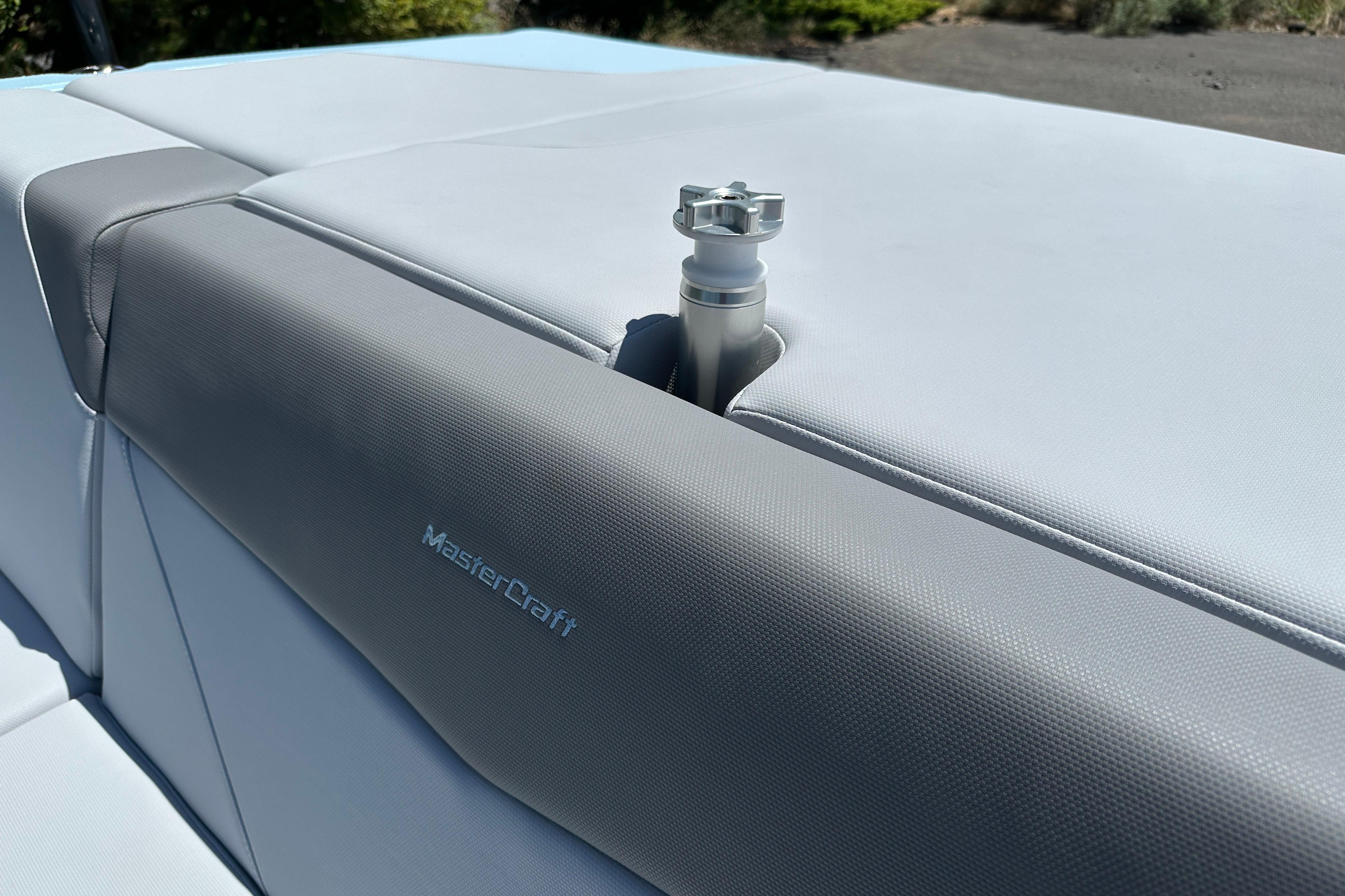 2023 MasterCraft NXT23 boat seat with gray upholstery and a metal fixture.