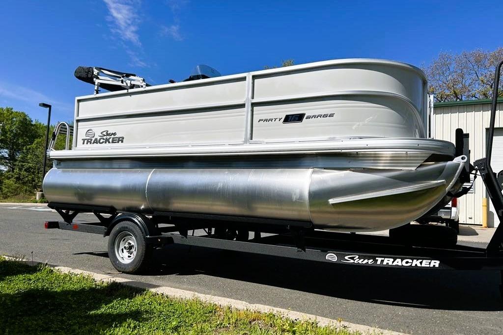 2026 Sun Tracker Party Barge 16 DLX pontoon boat on trailer, parked outdoors.