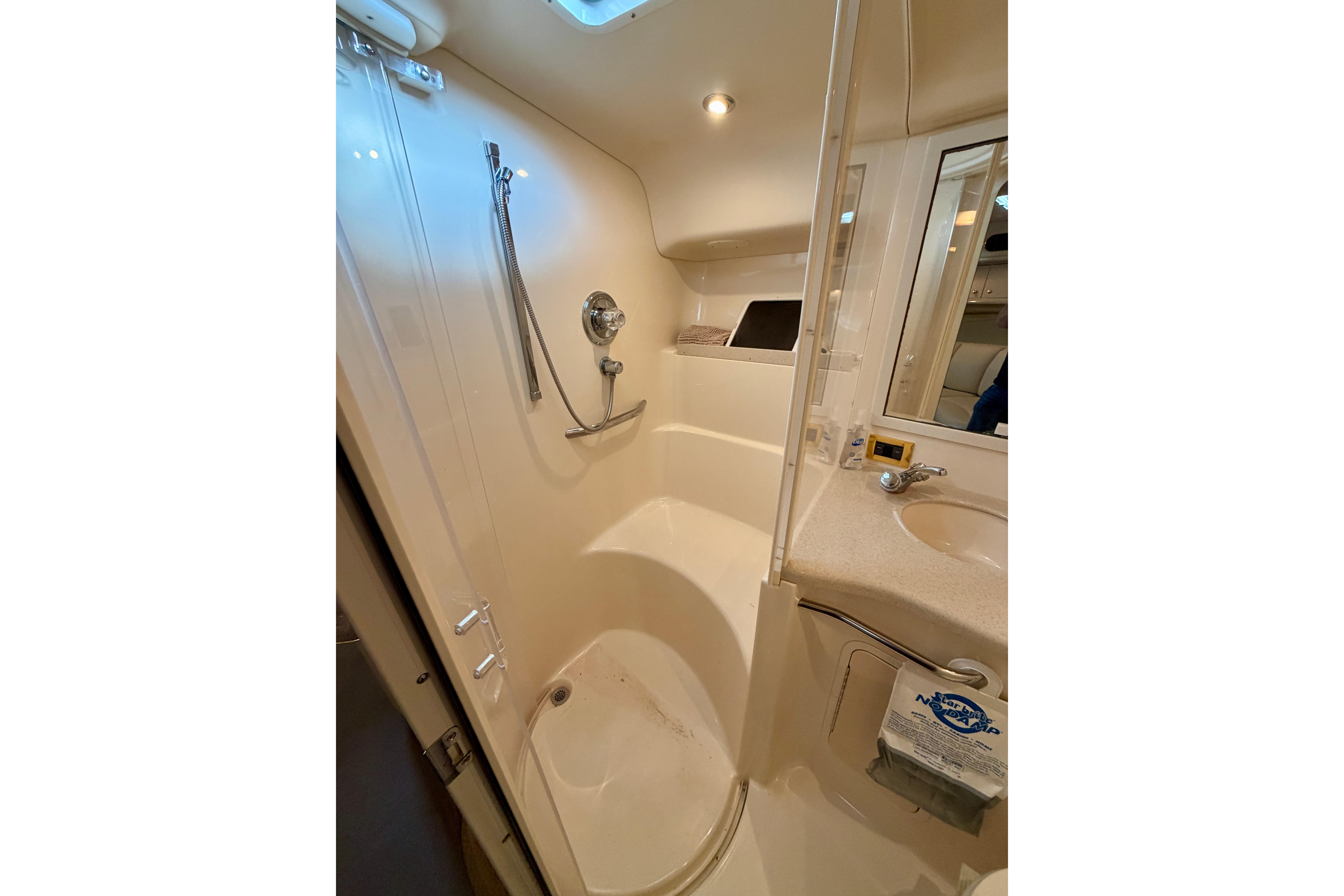 Bathroom interior of 1999 Sea Ray 400 Sundancer yacht, featuring shower and sink.