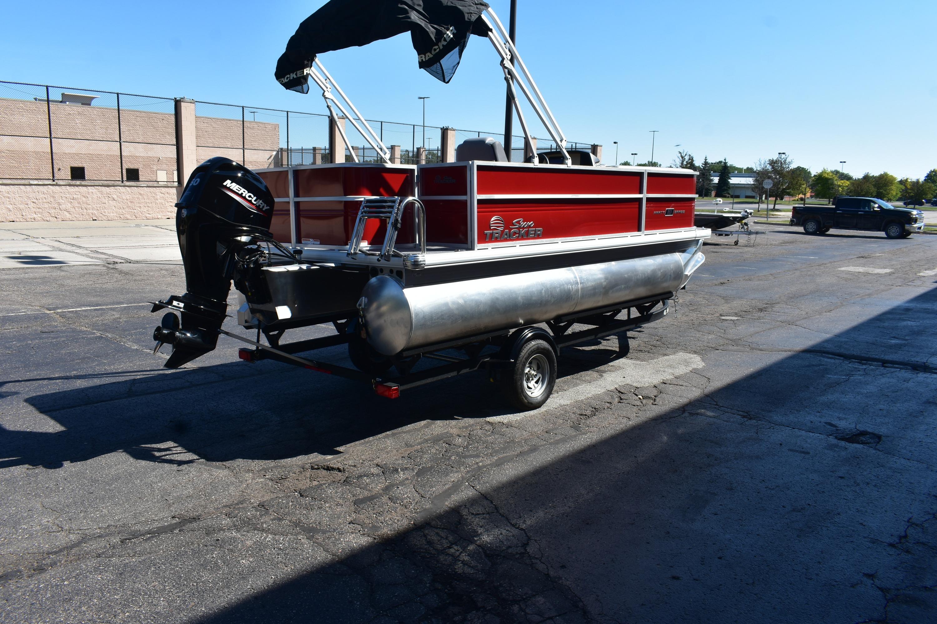 2026 Sun Tracker Party Barge 18 DLX pontoon boat on trailer, parked outdoors.