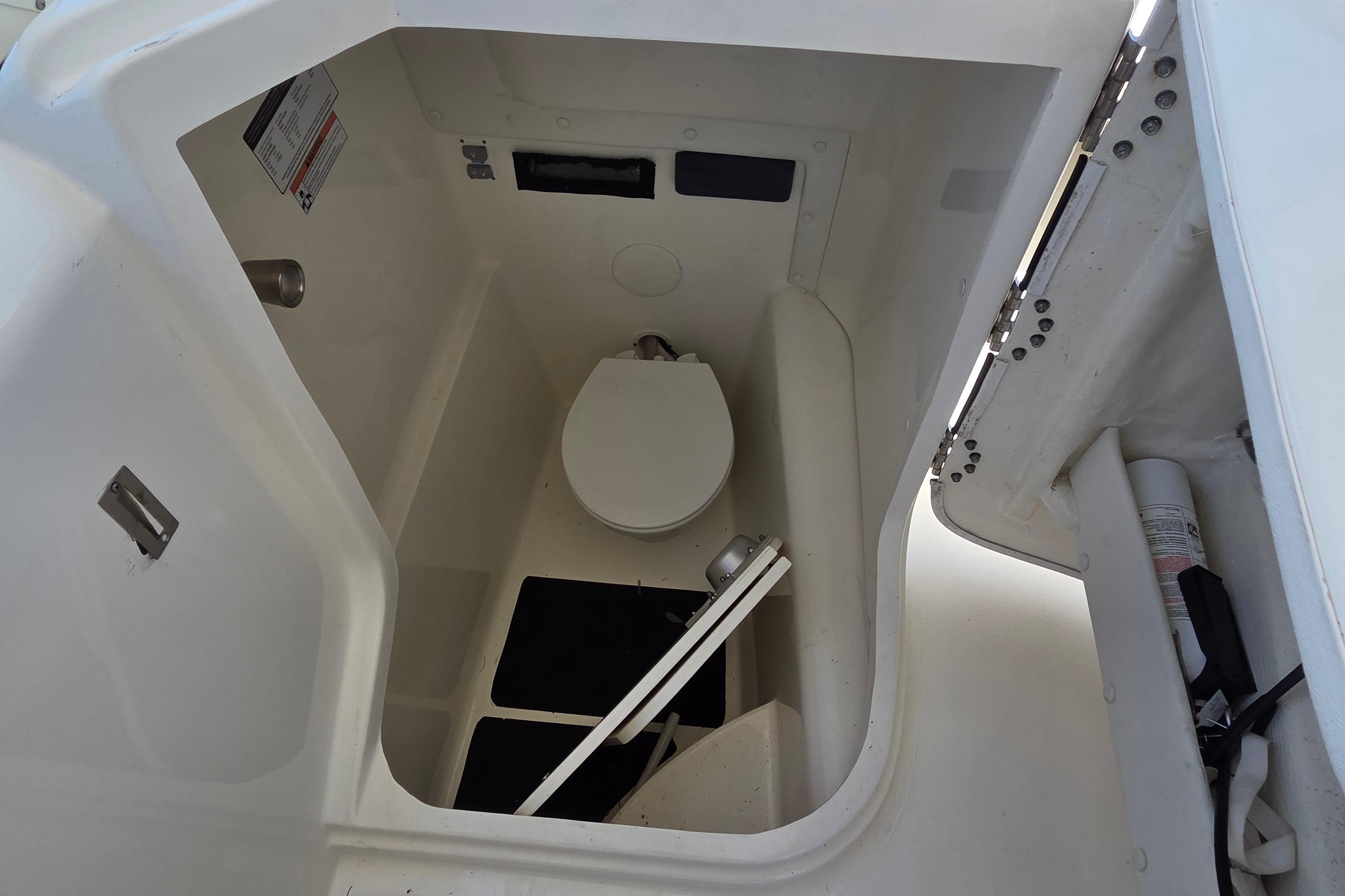Interior view of a 2022 World Cat 255 DC boat's compact bathroom area.