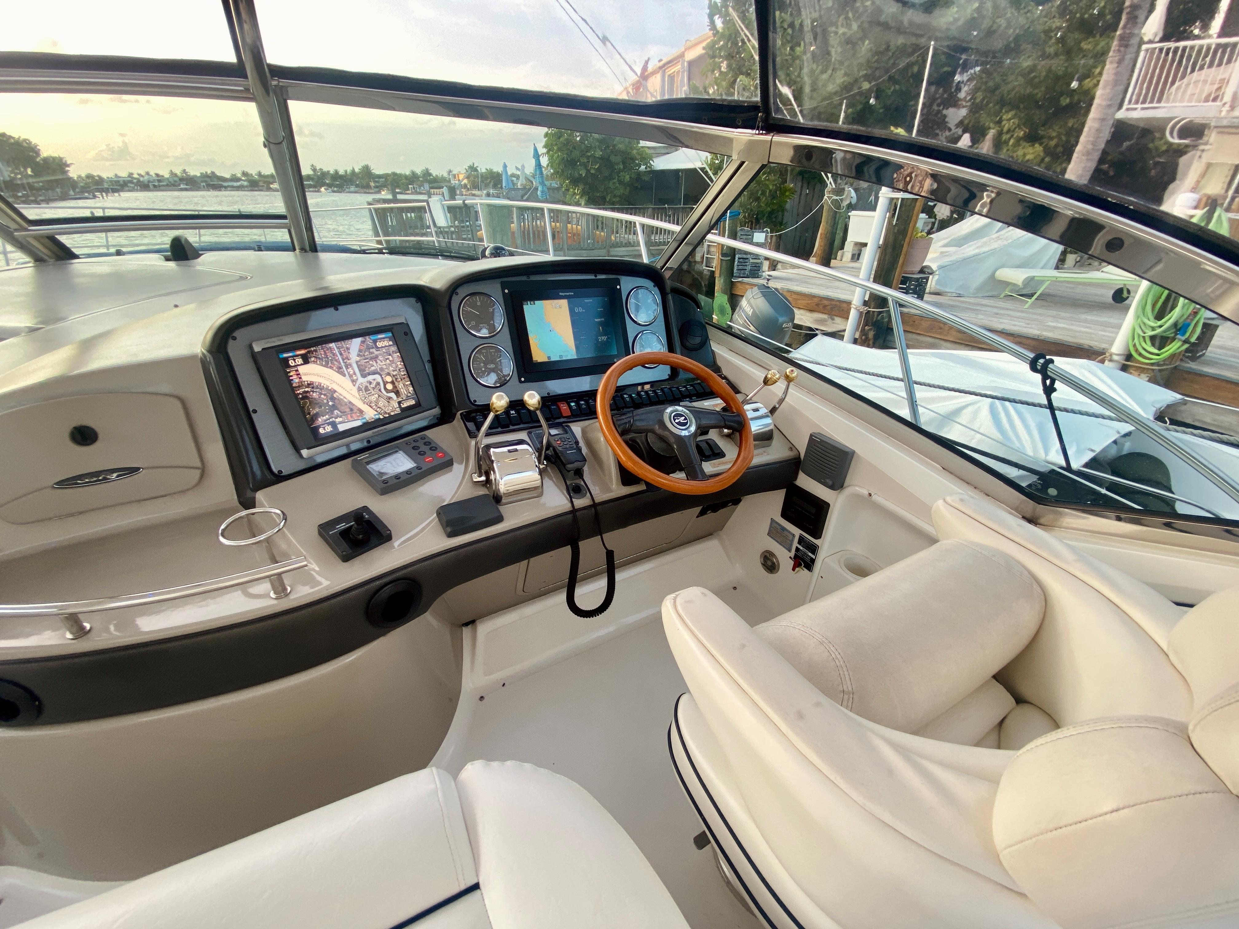 Helm of 2005 Sea Ray 420 Sundancer with navigation screens and leather seats.
