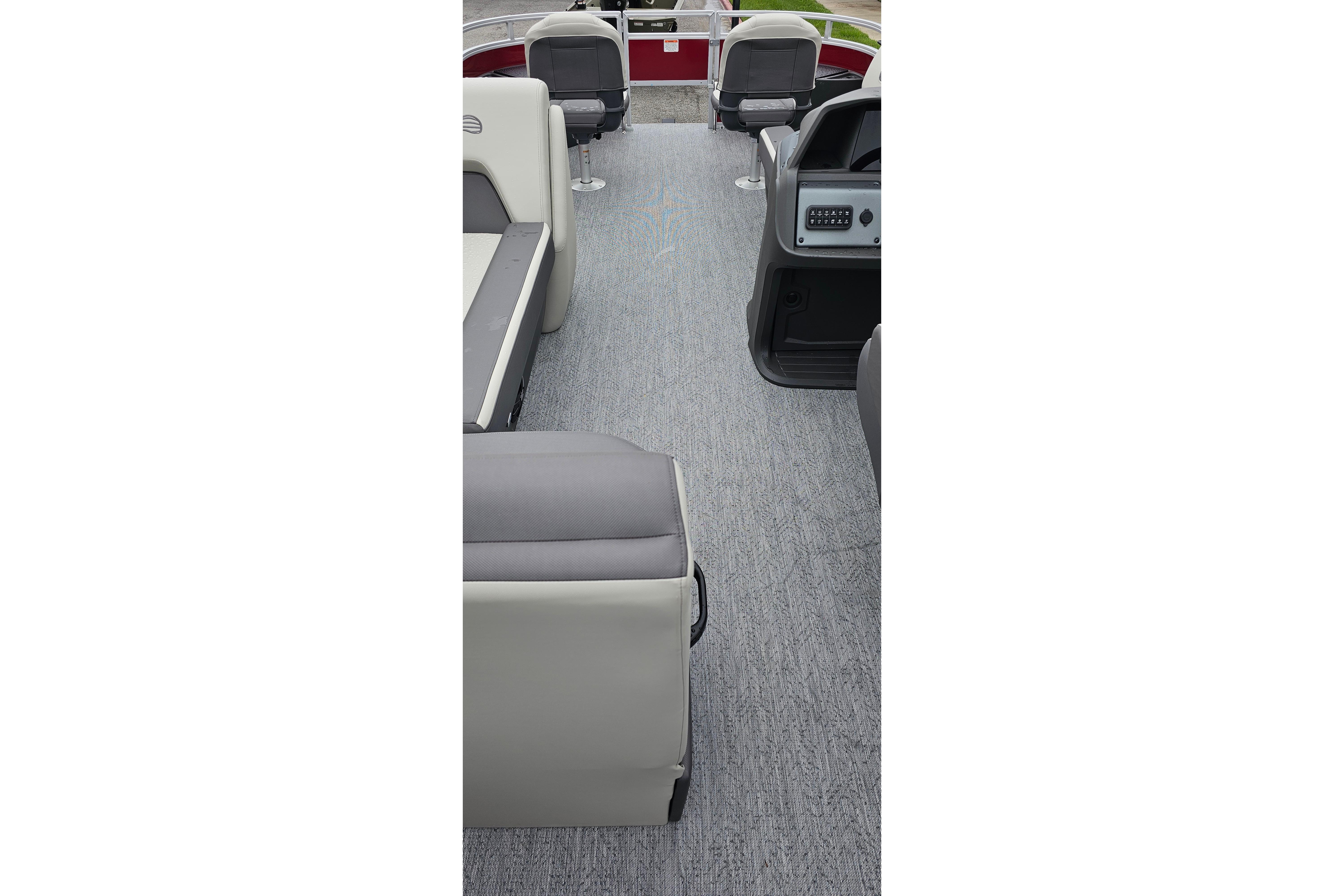 2026 Sun Tracker Fishin' Barge 22 DLX interior with gray seating and carpeted floor.