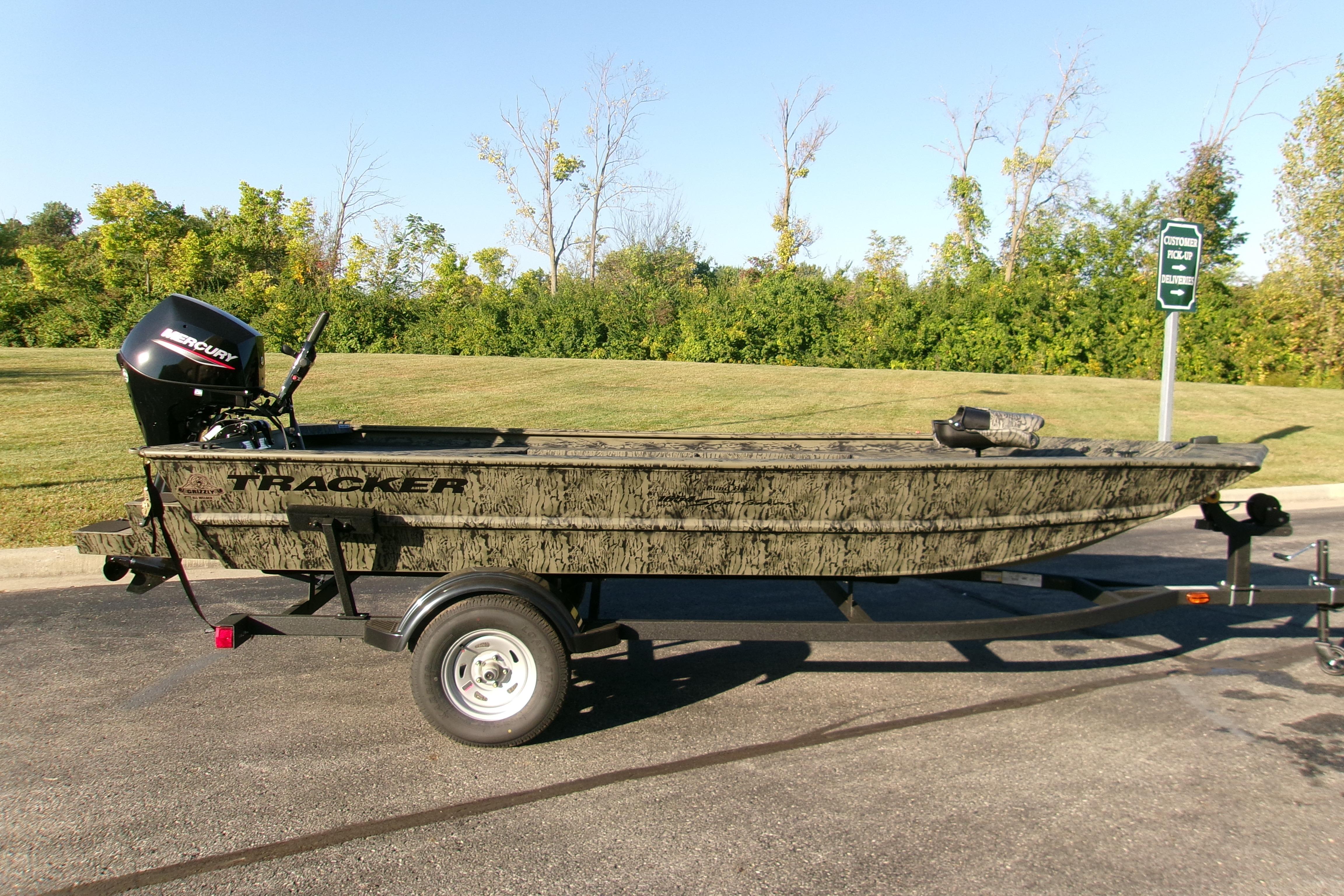 2026 Tracker Grizzly 1654 T Sportsman boat on trailer, parked outdoors.