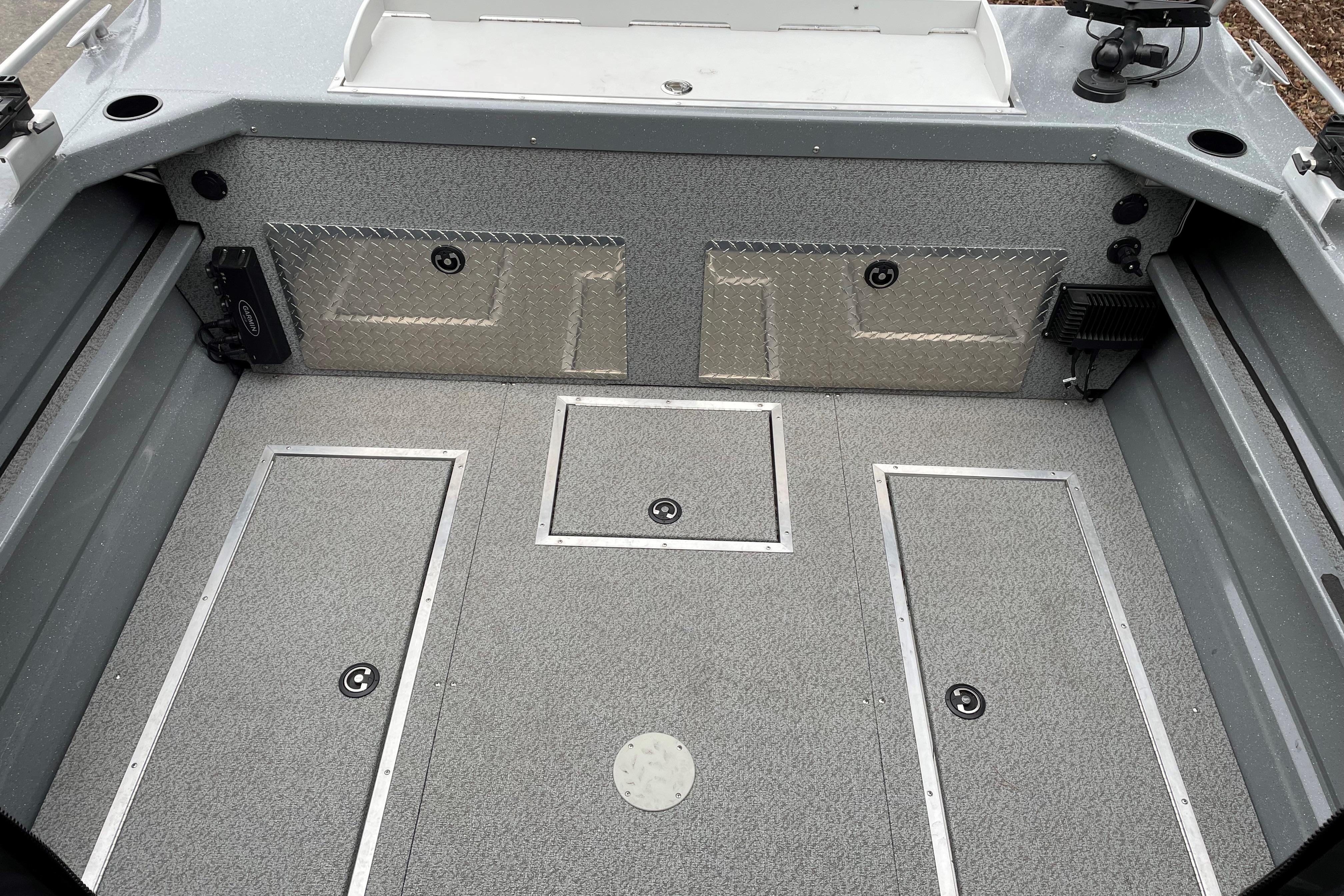 2024 Spartan 200 Astoria boat interior with storage compartments and diamond plate accents.