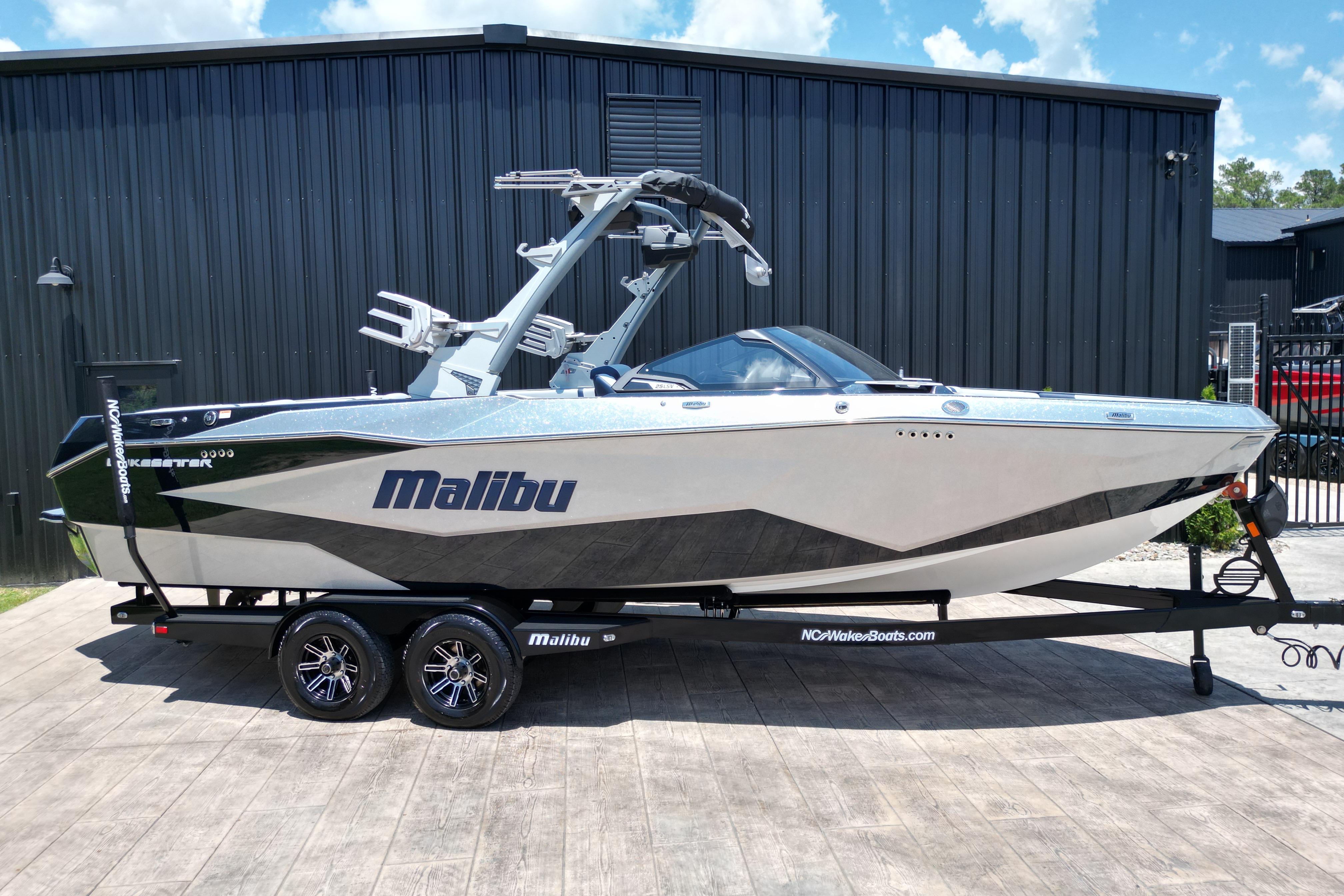 2025 Malibu Wakesetter 25 LSV boat on trailer, sleek design, parked outdoors.