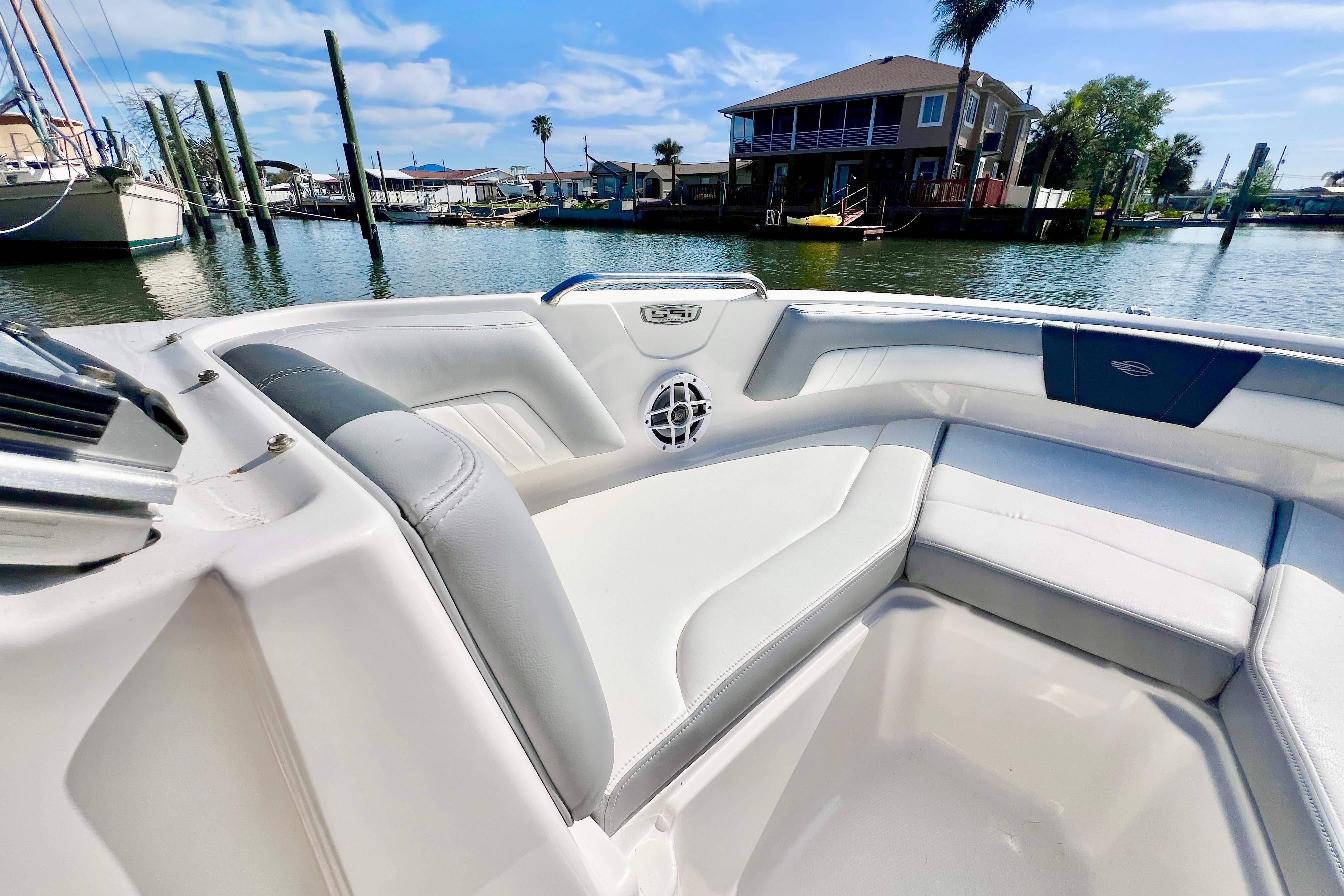 2023 Chaparral 21 SSi OB boat interior with waterfront view, showcasing sleek seating design.
