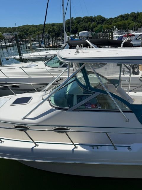 A 1995 Pro-Line 2950 Walkaround docked at a marina. It features a spacious deck and hardtop.