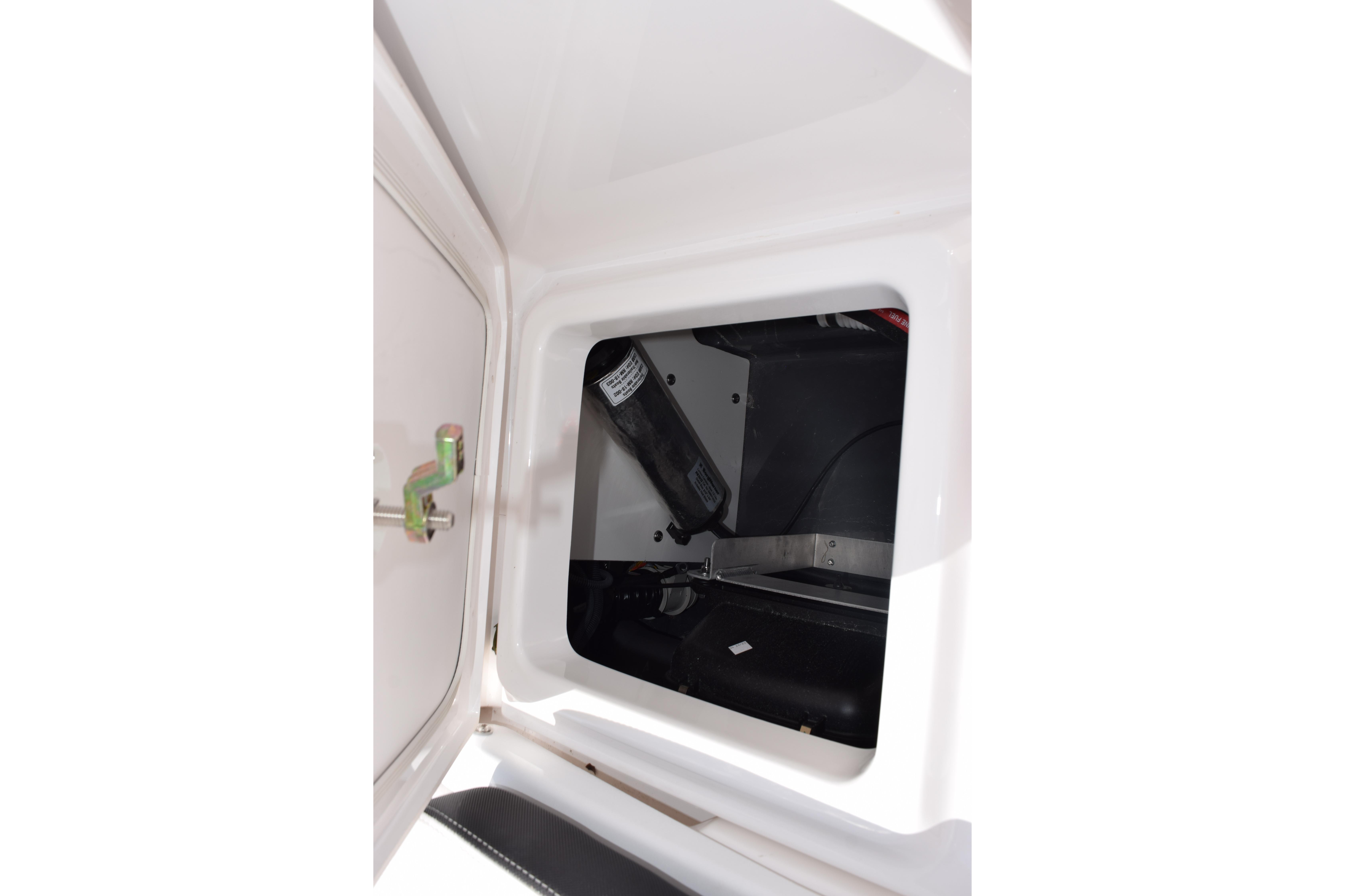 Storage compartment inside 2026 Yamaha Boats 255 FSH Sport H, featuring secure latch and interior view.