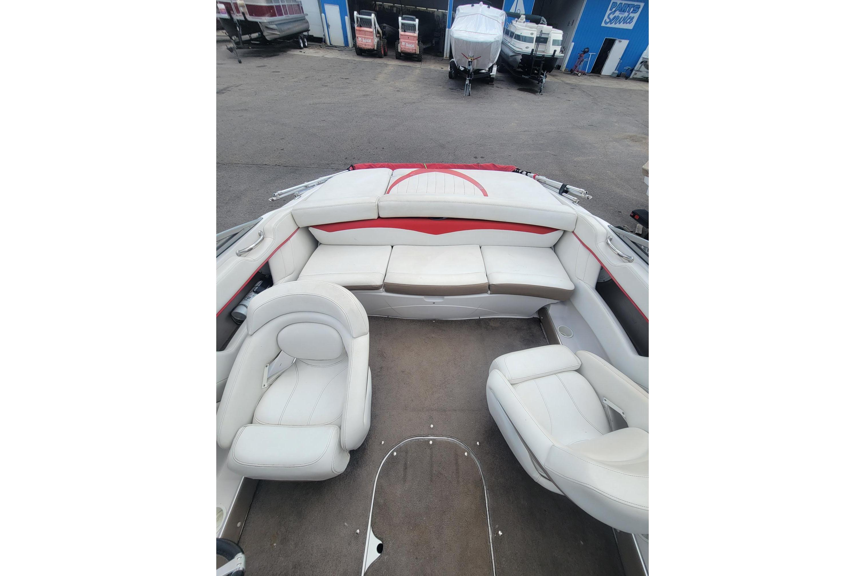 2007 Four Winns 200 Horizon boat interior with white and red seating, parked outdoors.