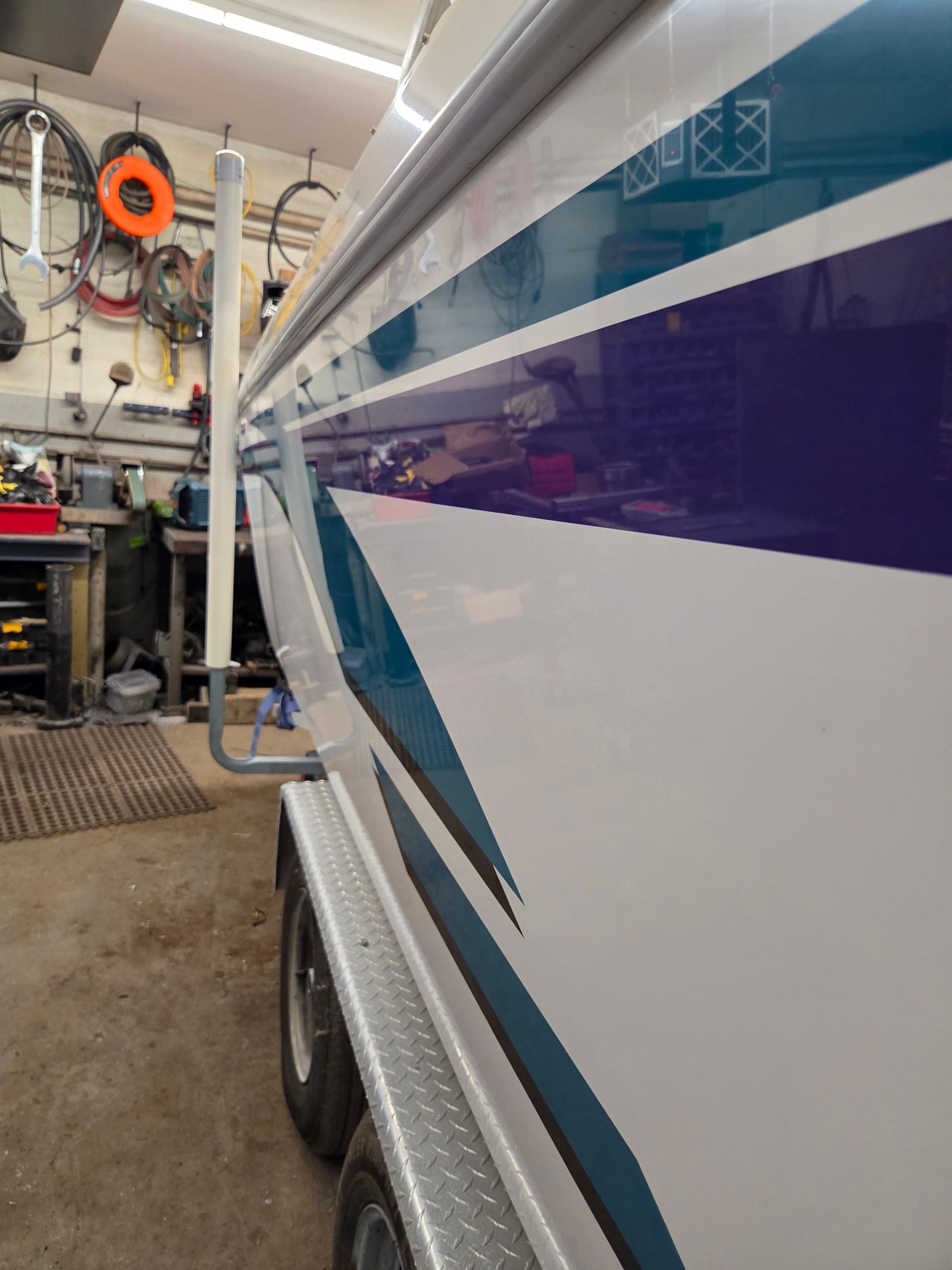 Side view of a 1998 Powerquest Enticer 290 FX in a workshop.