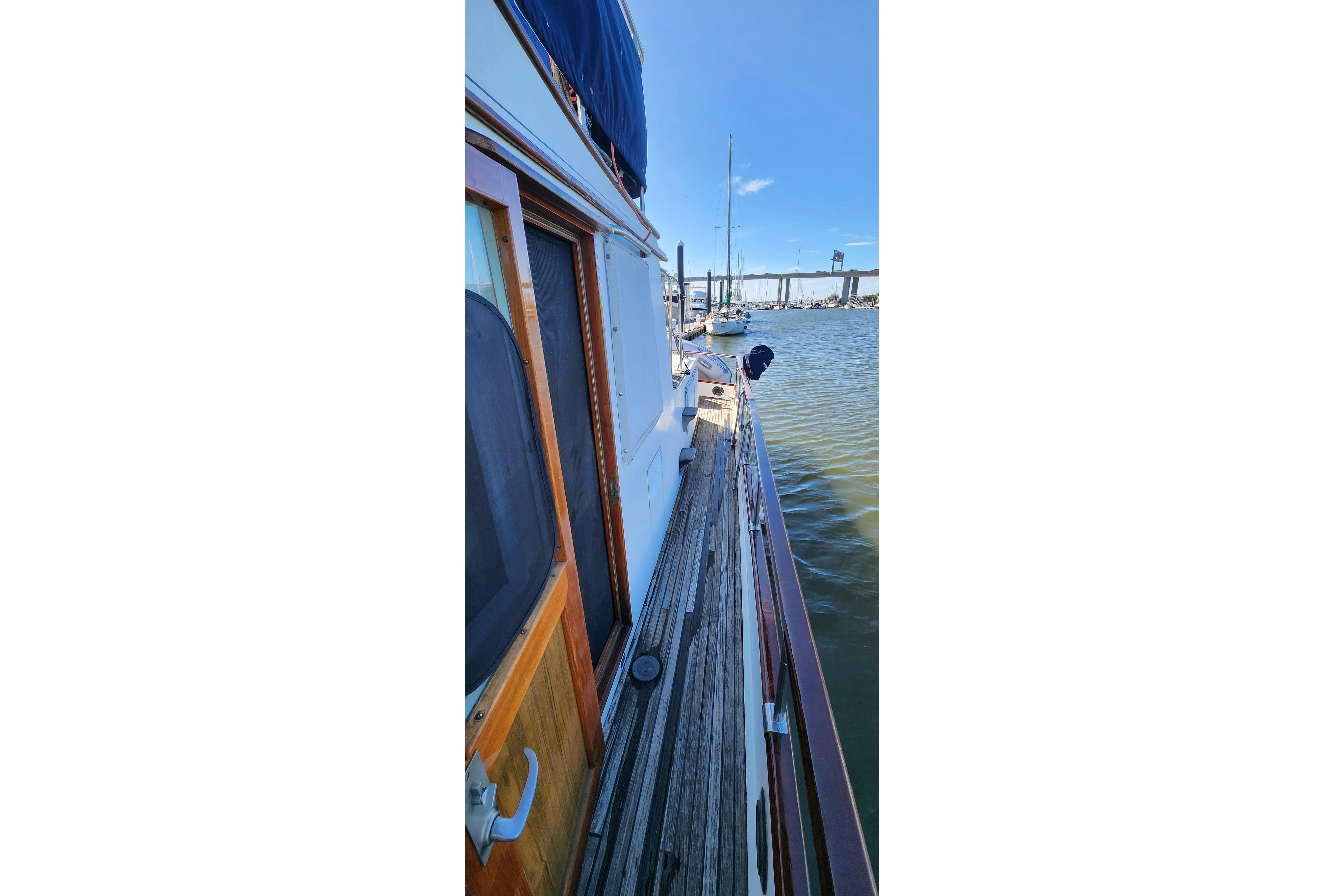 1987 Grand Banks 36 Classic yacht docked, showcasing wooden deck and marina view.