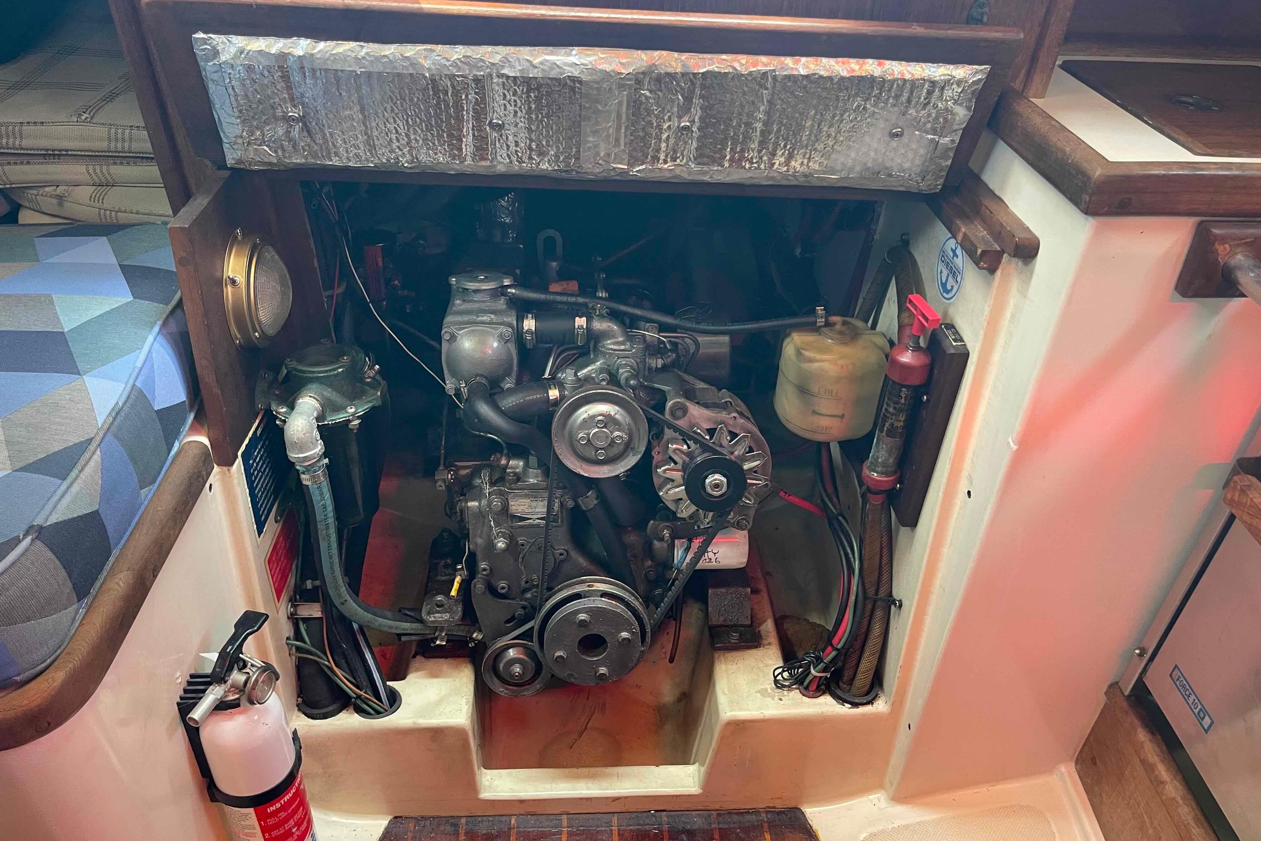 Engine compartment of a 1987 Pacific Seacraft 34 sailboat, featuring mechanical components and safety equipment.