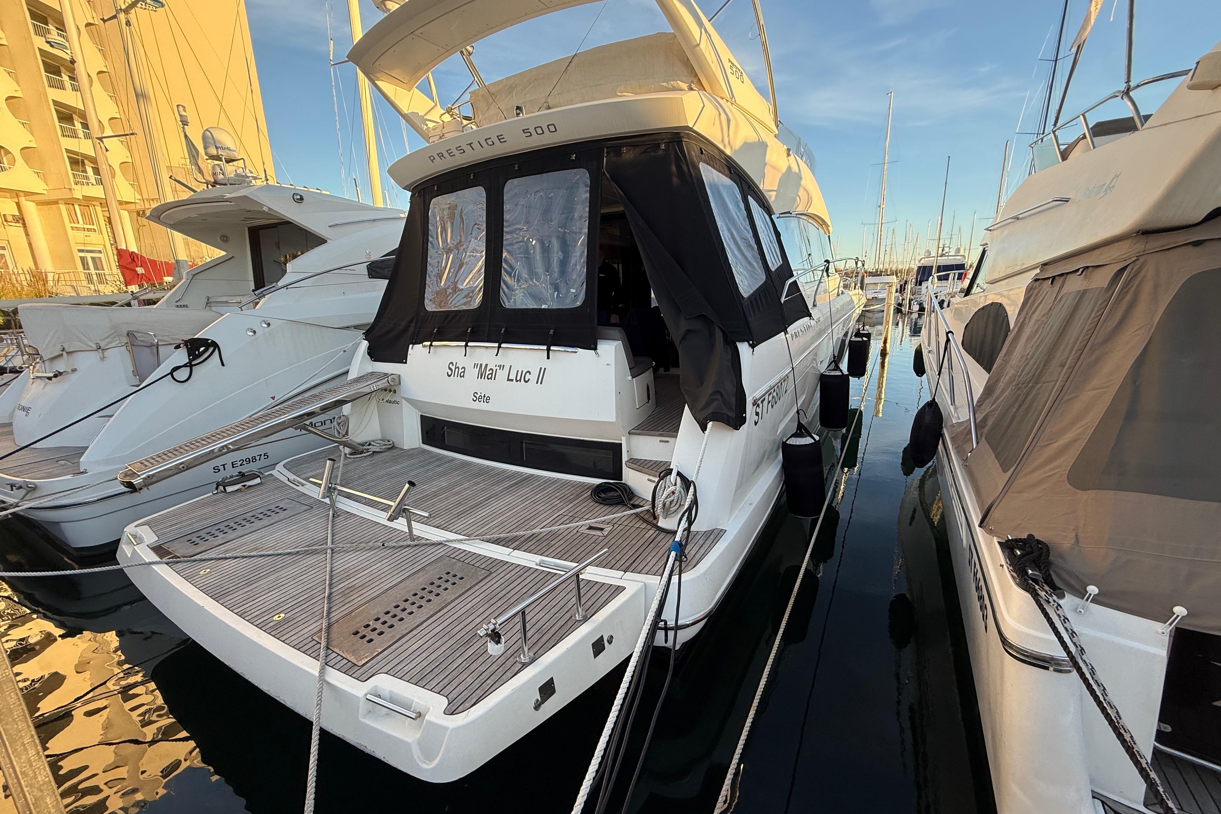 2018 Prestige 500 yacht docked at marina, rear view with covered deck.