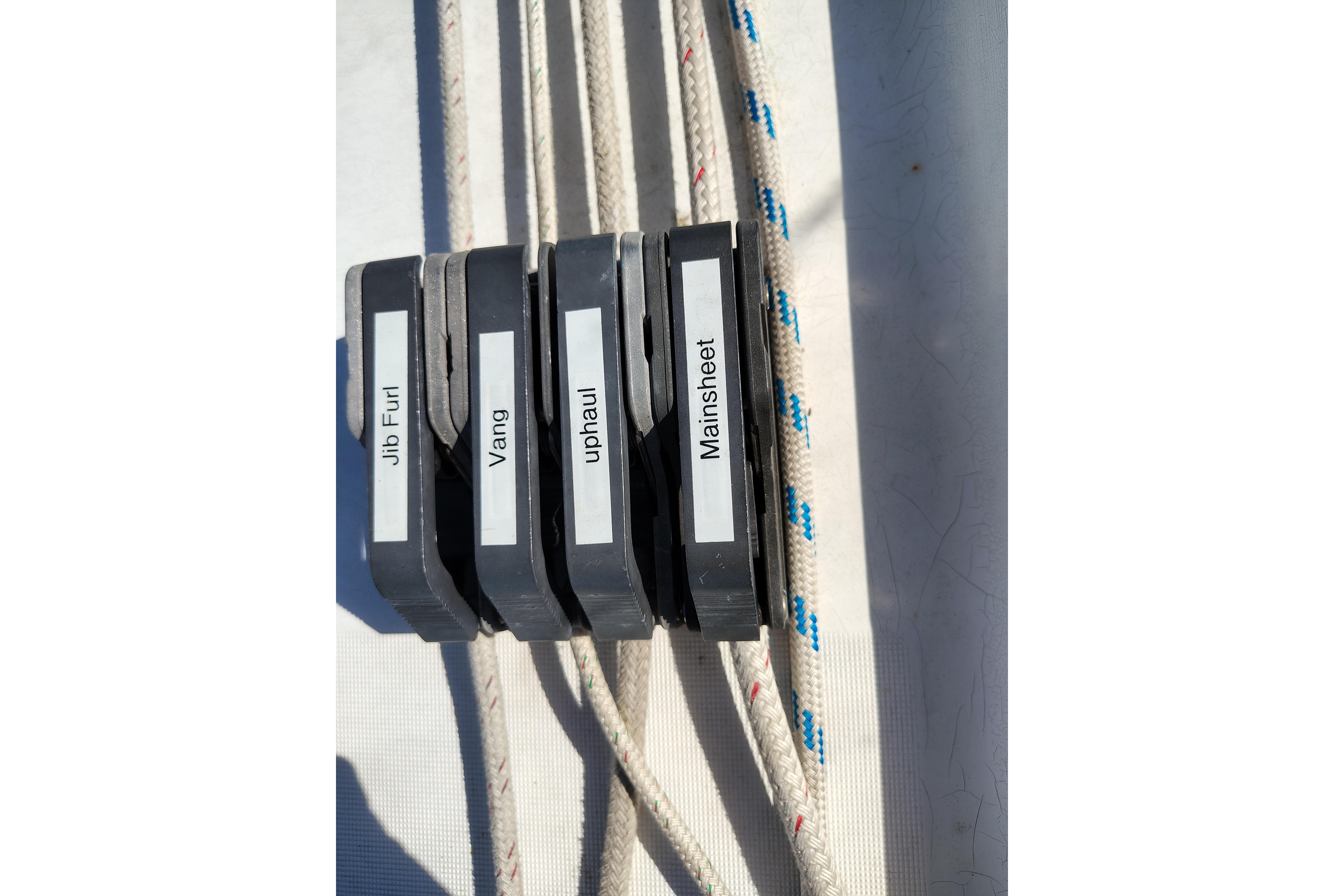 Sailing controls on a 2001 Beneteau Oceanis 411, labeled jib furl, vang, uphaul, mainsheet.
