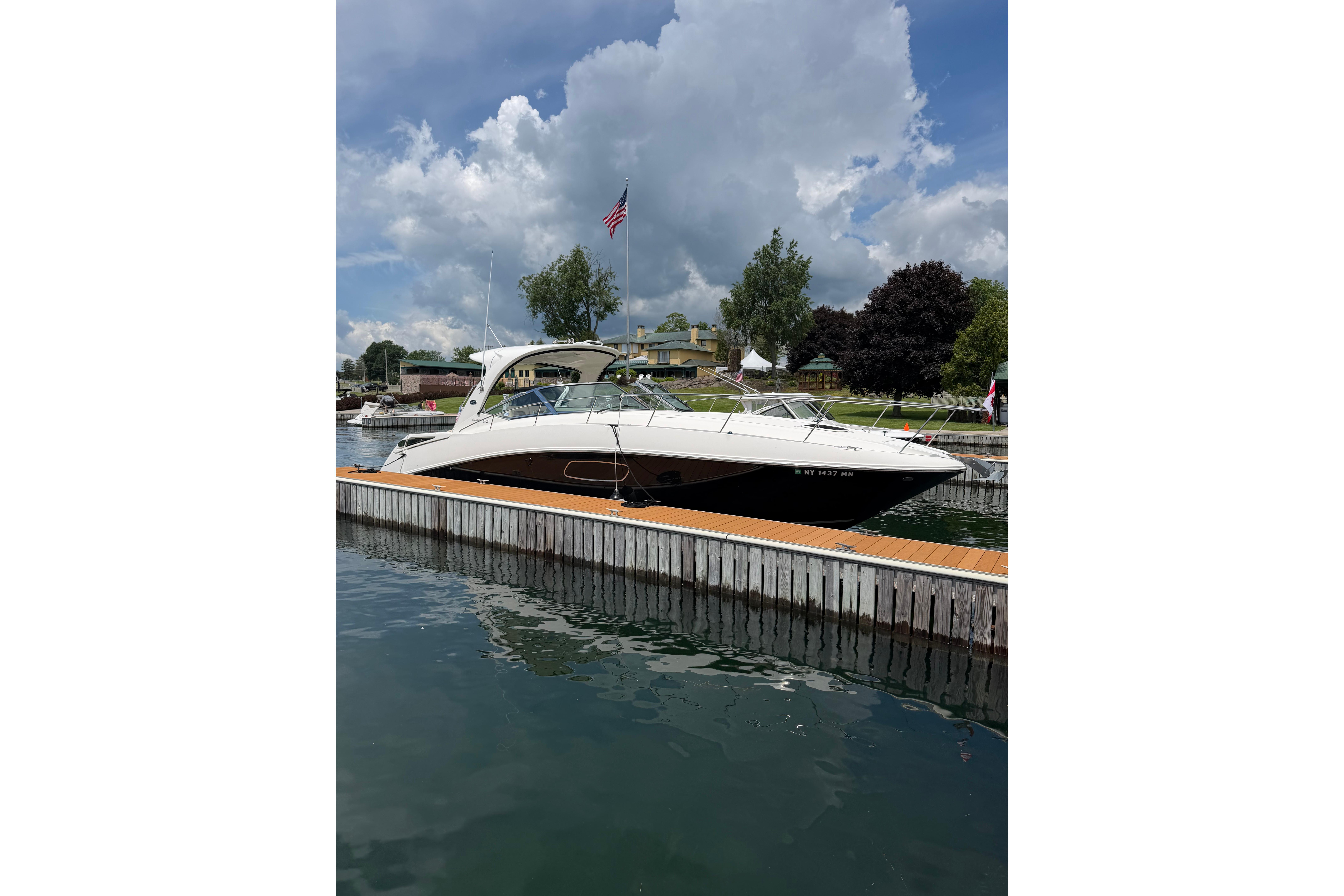 2012 Sea Ray Sundancer 370 docked at marina under cloudy sky.