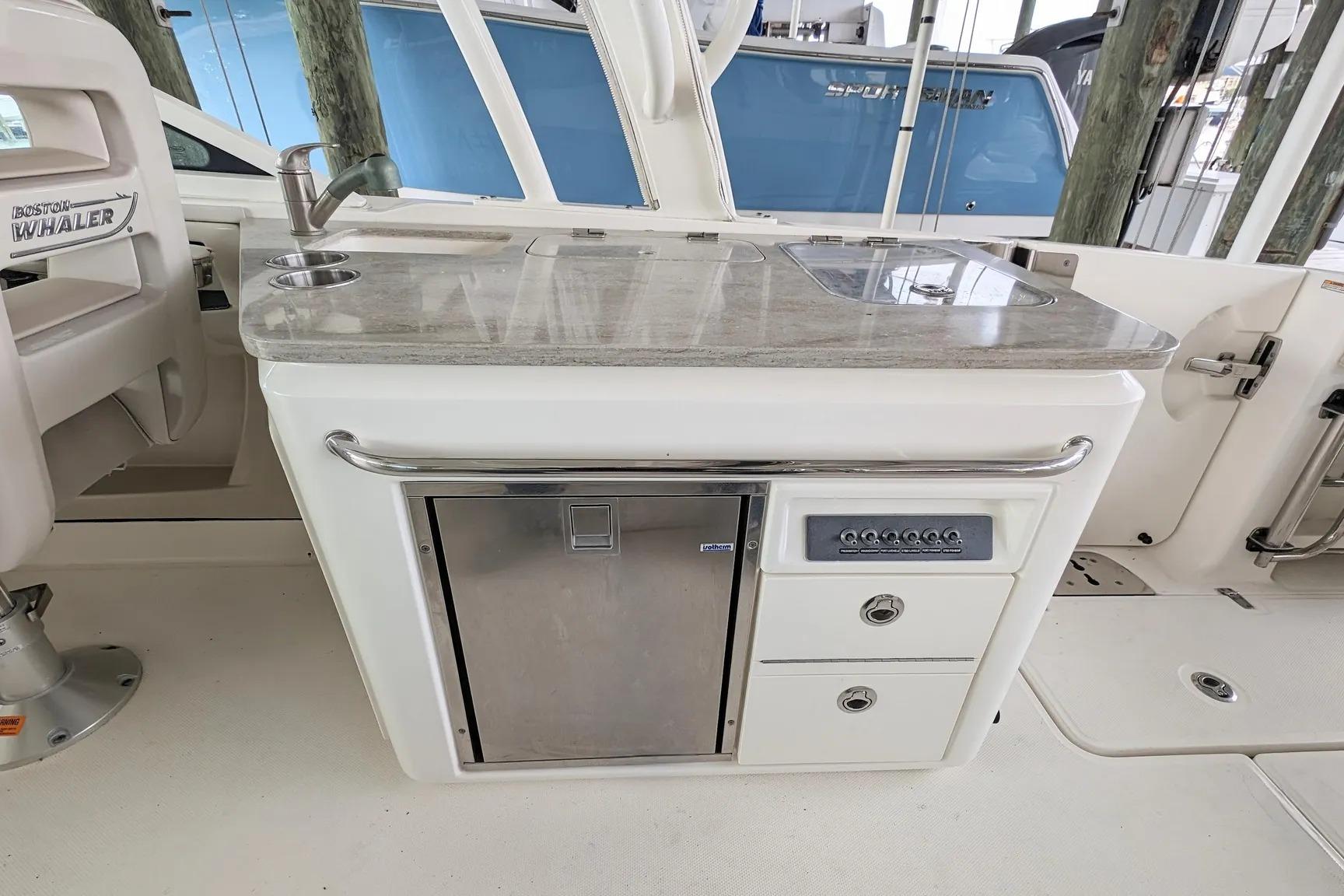 2017 Boston Whaler 320 Vantage boat interior with kitchenette and stainless steel appliances.