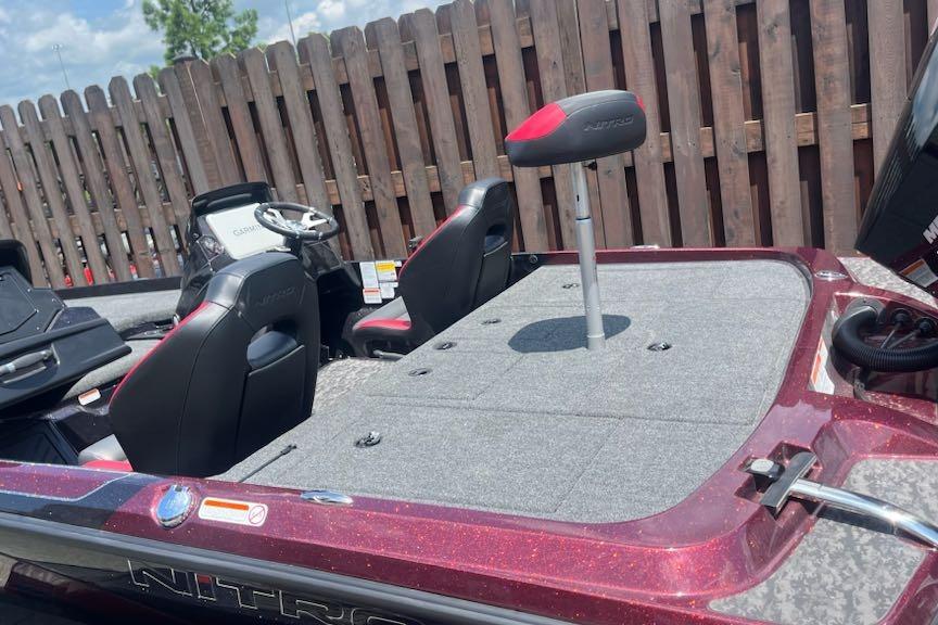2026 Nitro Z21 XL Pro boat with red accents and seating, parked by a wooden fence.