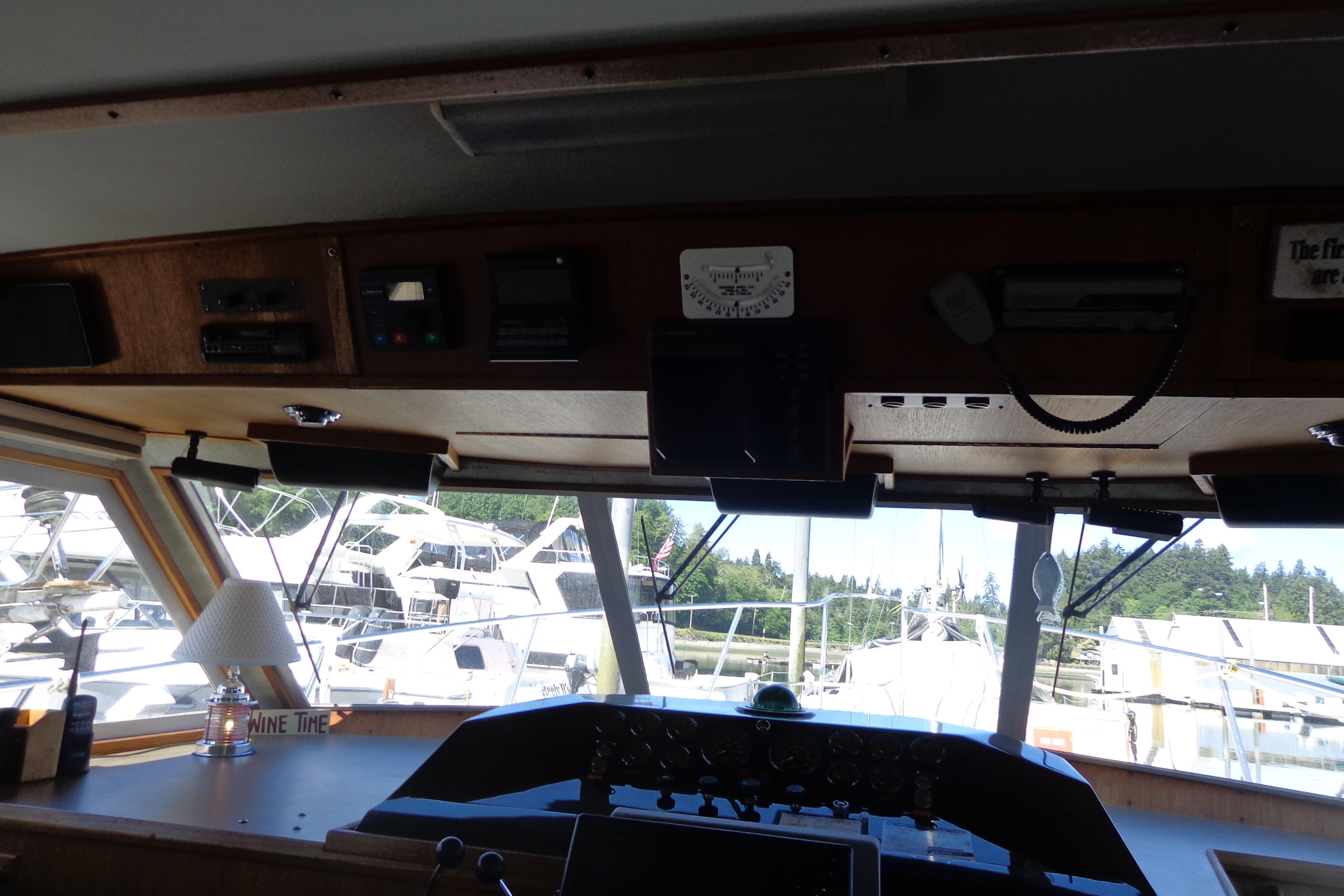 Interior view of 1992 Cruise-A-Home Corsair 4200 boat cockpit with marina background.