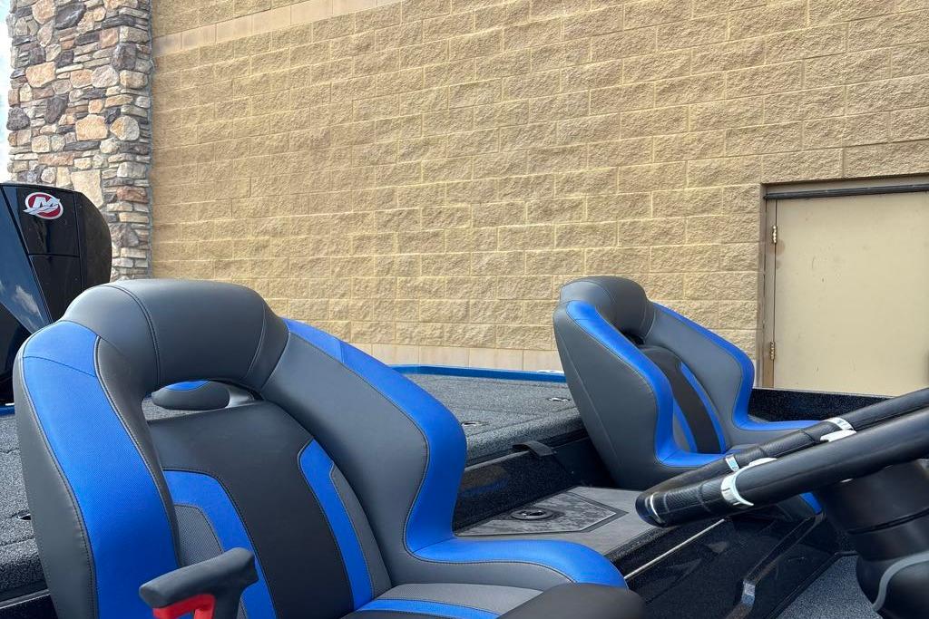 2026 Nitro Z20 XL Pro boat with blue and gray seating, parked near a stone wall.