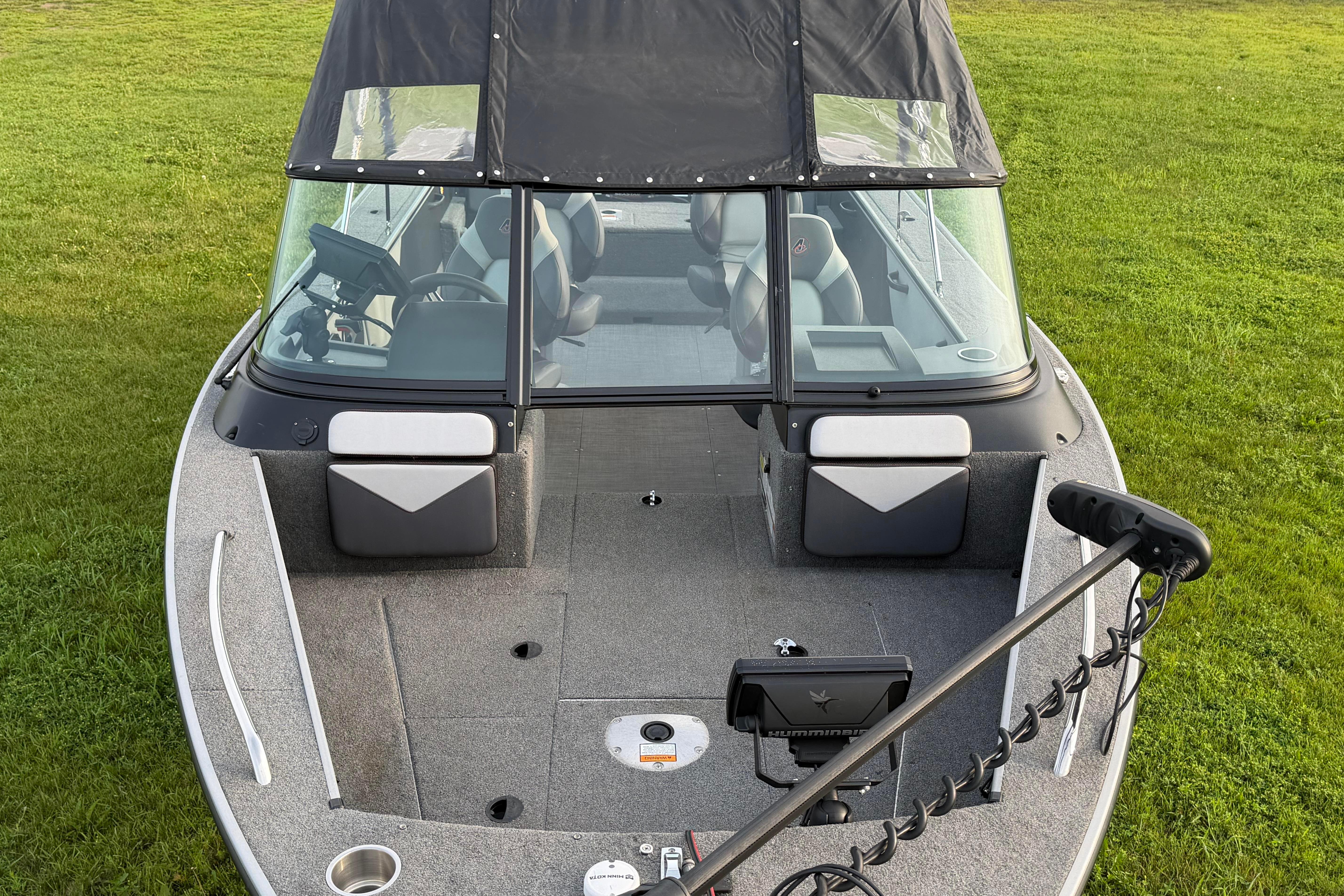 2019 Alumacraft Trophy 205 boat with canopy on grassy field.