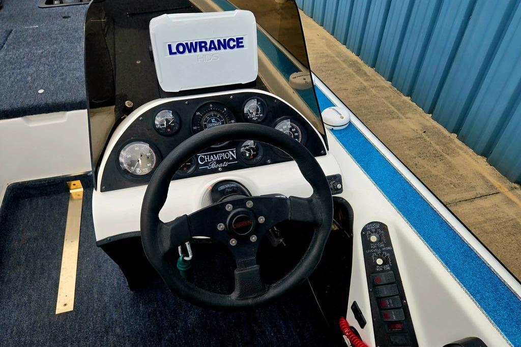 1996 Champion 181 SX boat dashboard with steering wheel and Lowrance GPS system.