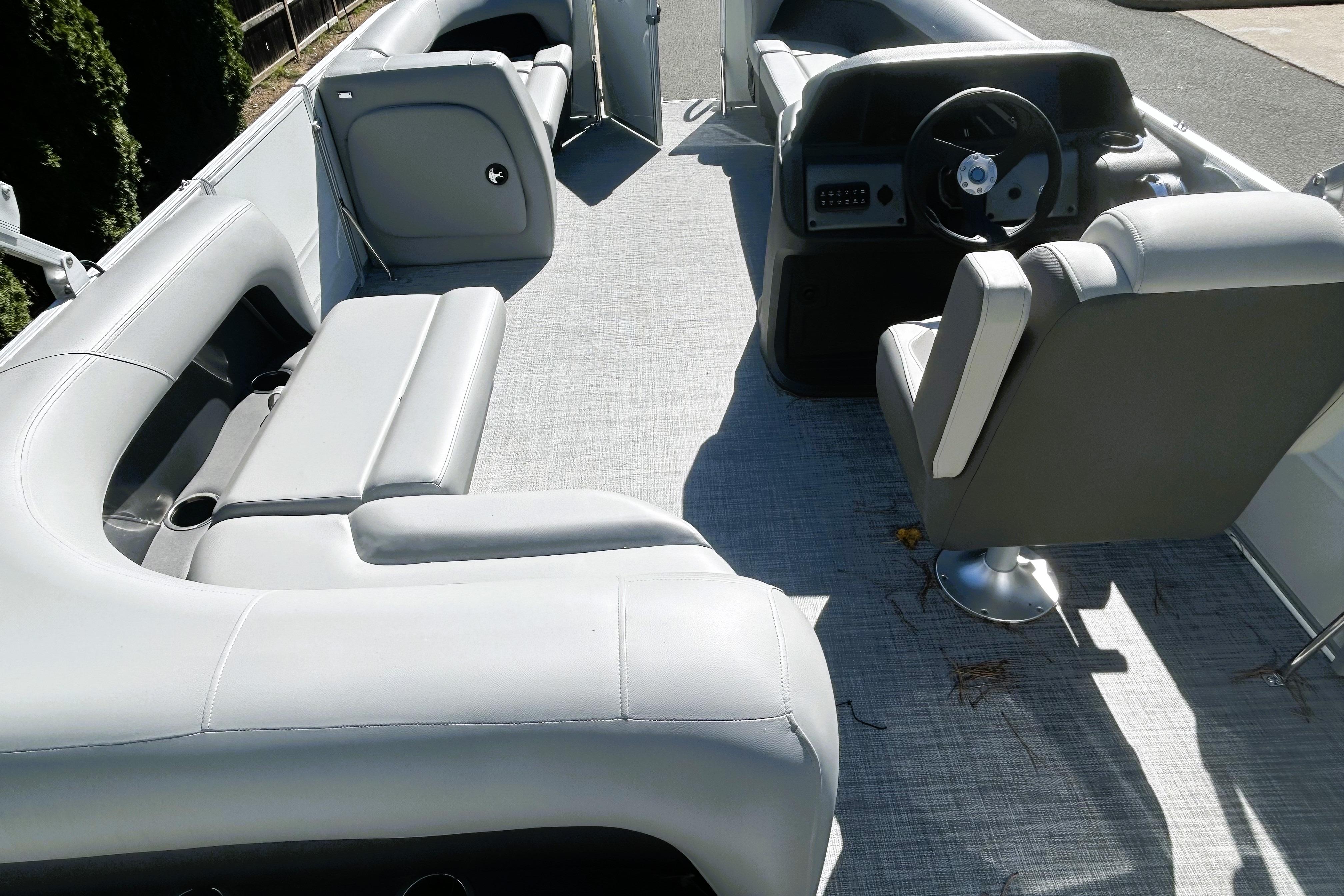2026 Sun Tracker Party Barge 18 DLX interior with gray seating and steering console.