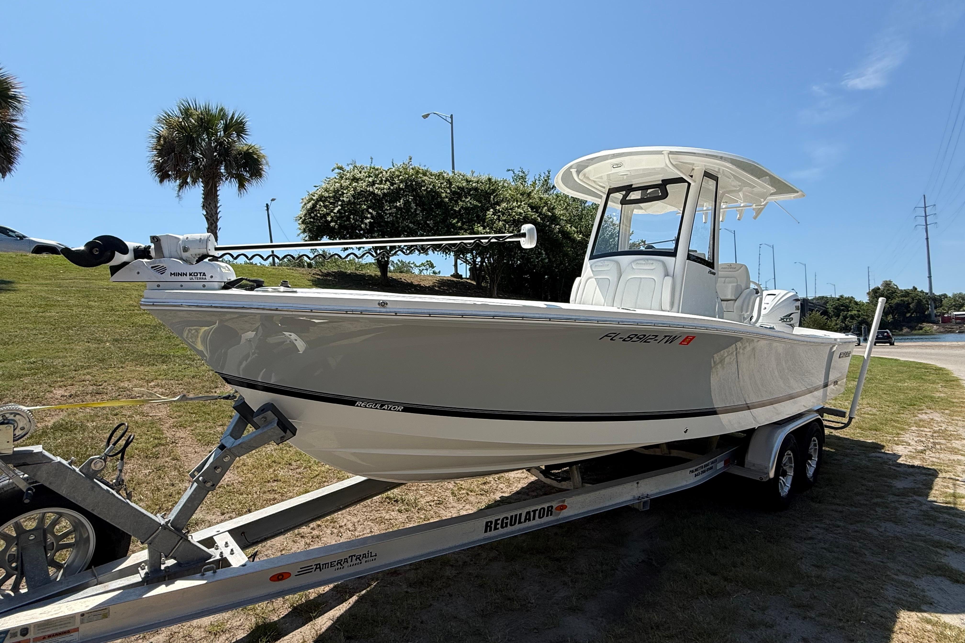 2023 Regulator 26XO boat on trailer, parked outdoors under clear blue sky.