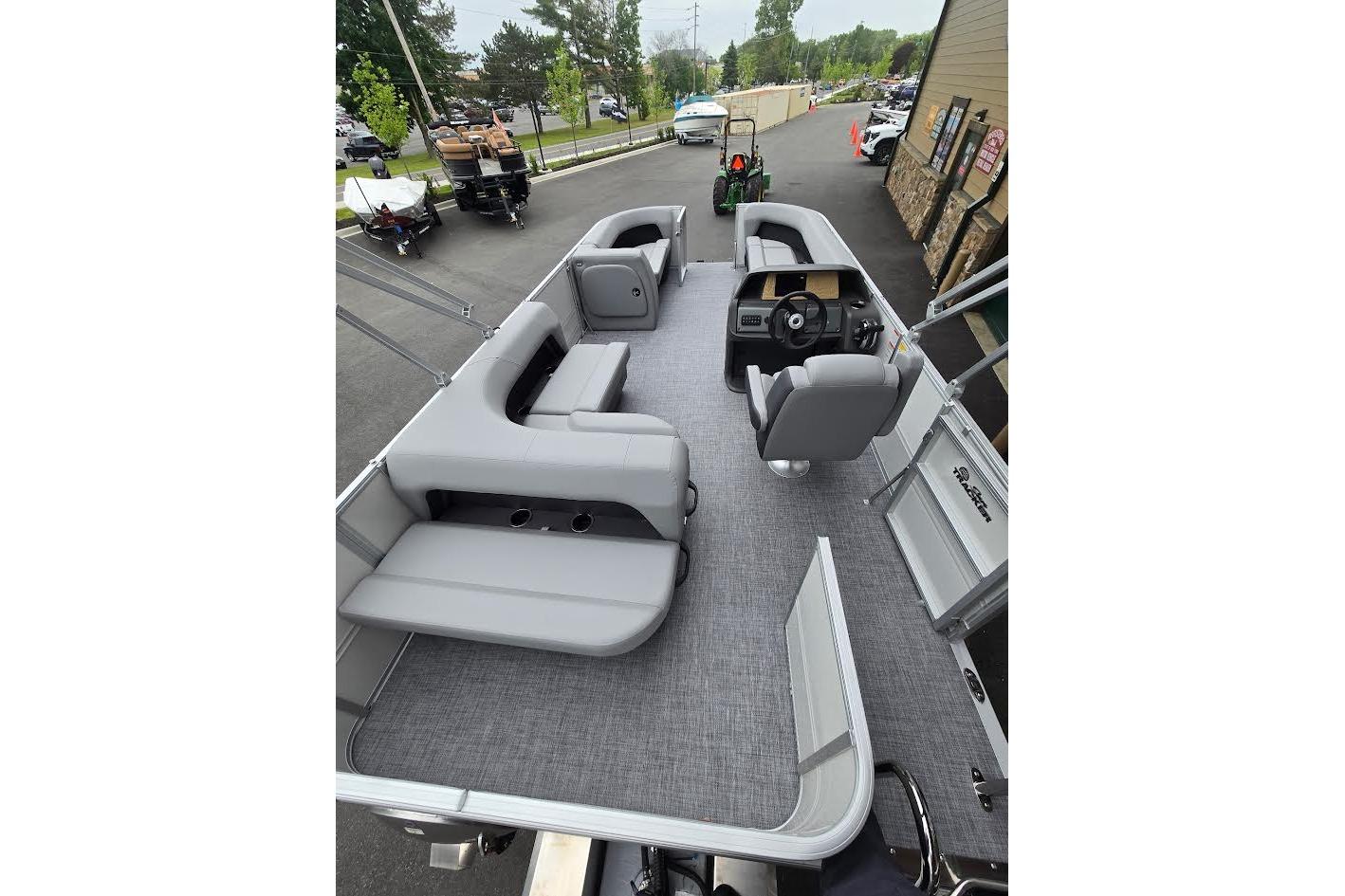 2026 Sun Tracker Party Barge 18 DLX interior with gray seating and steering console.