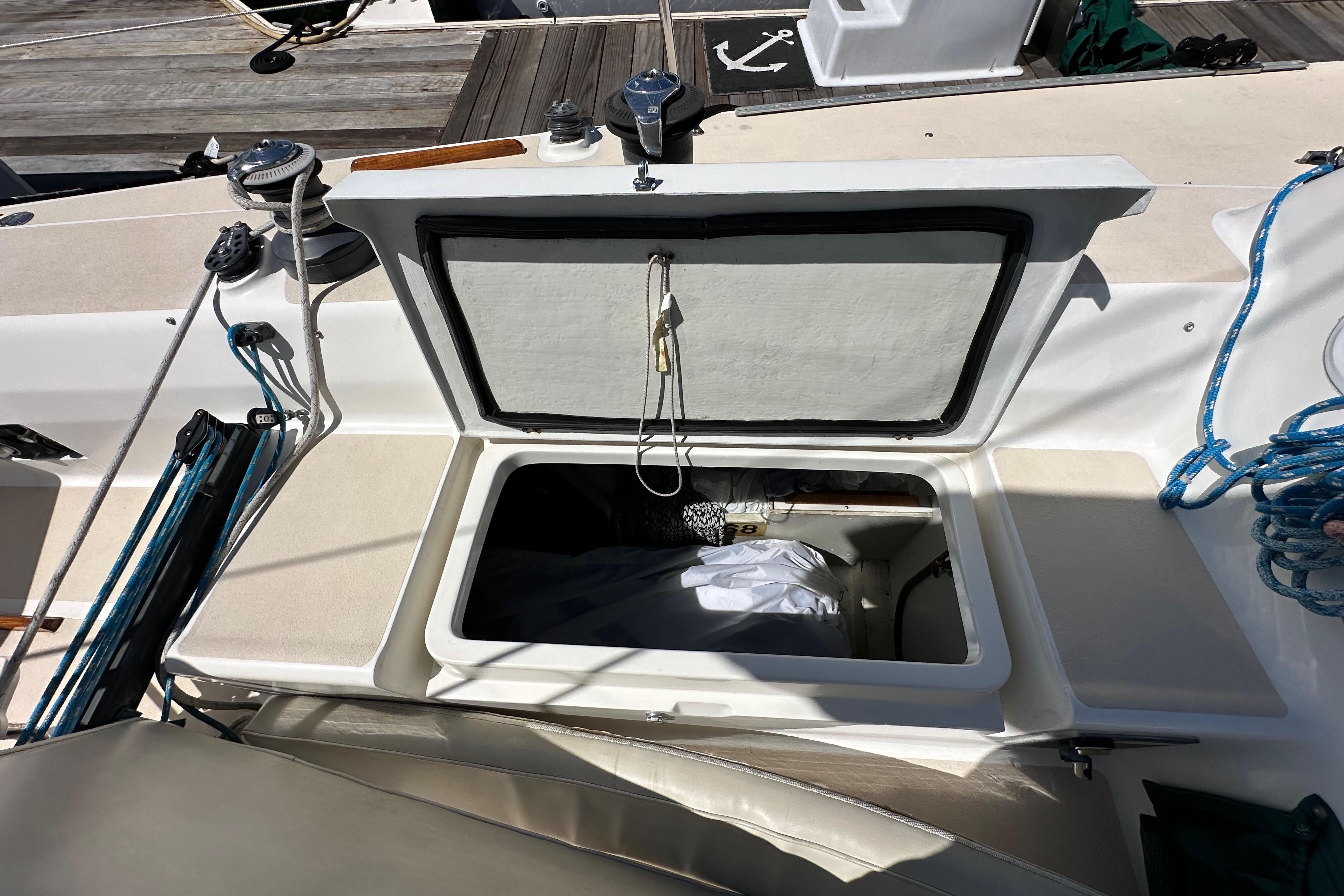 Open storage compartment on 1996 J Boats J/120 sailboat deck, with ropes and winches visible.