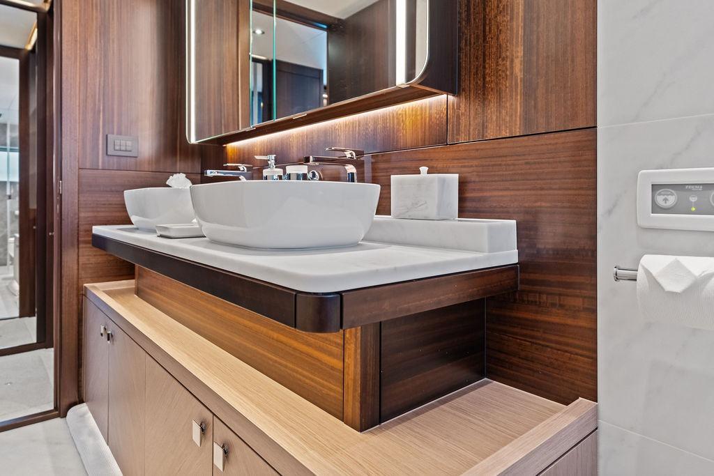 Luxurious bathroom interior of 2026 Sunseeker 88 Yacht with modern fixtures and elegant wood finishes.