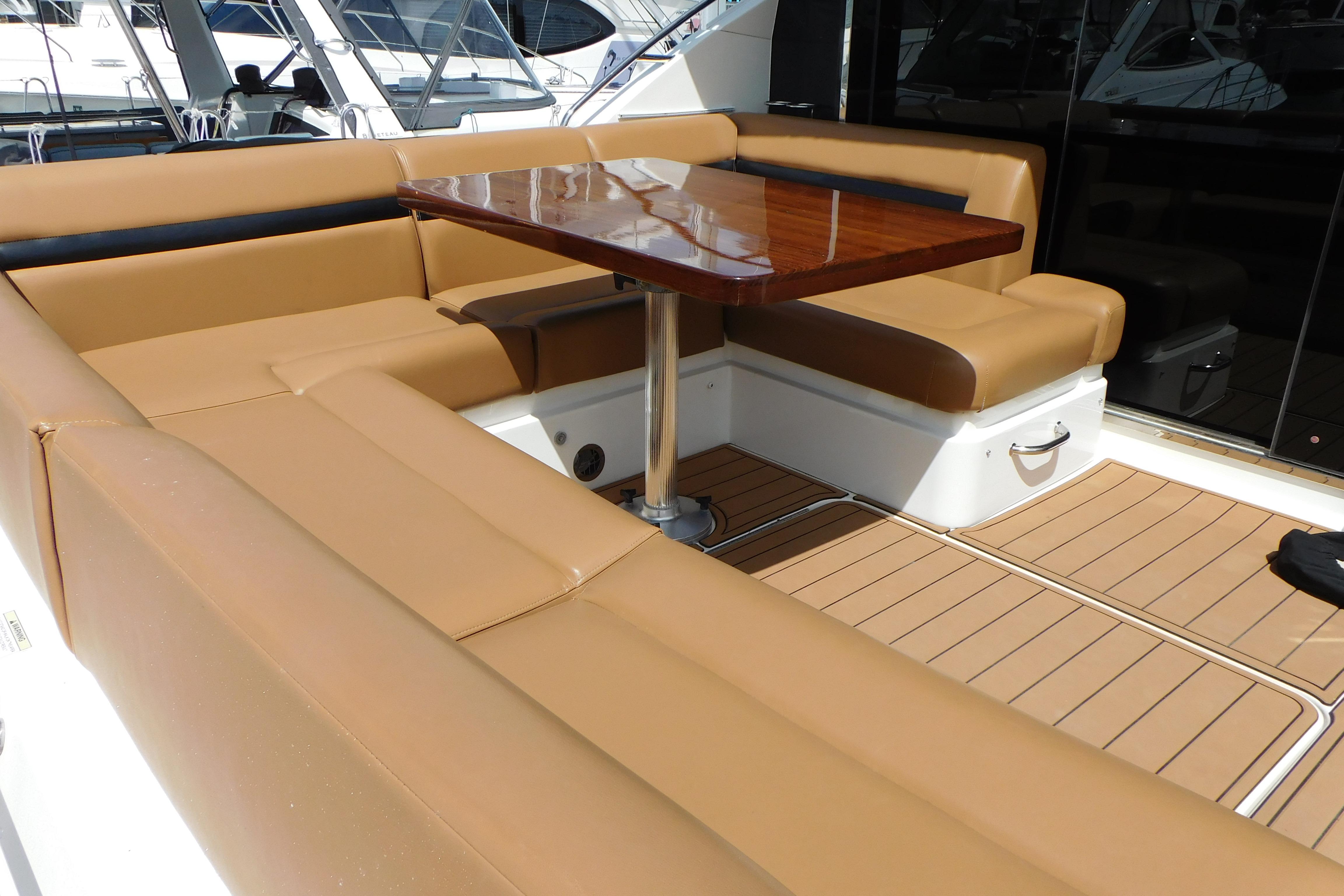 Luxurious seating area on 2013 Sea Ray 510 Sundancer yacht with wooden table.