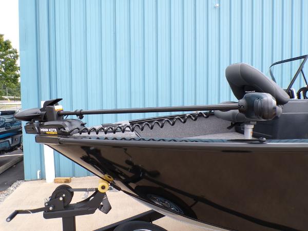 2025 Tracker Pro Guide™ V-175 Combo boat with trolling motor, parked by blue wall.