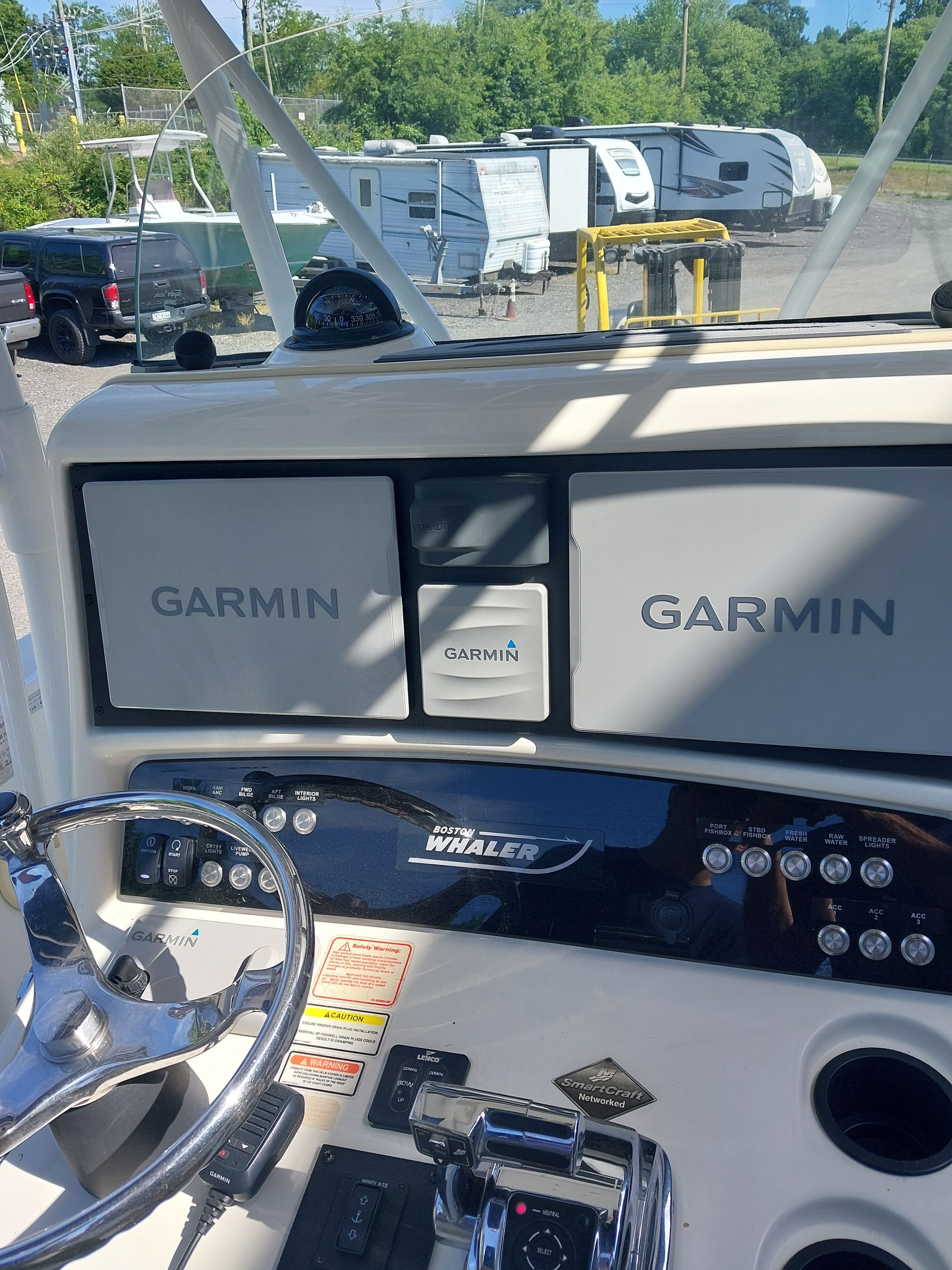 The image shows the cockpit of a 2005 Boston Whaler 240 Outrage with Garmin electronics.