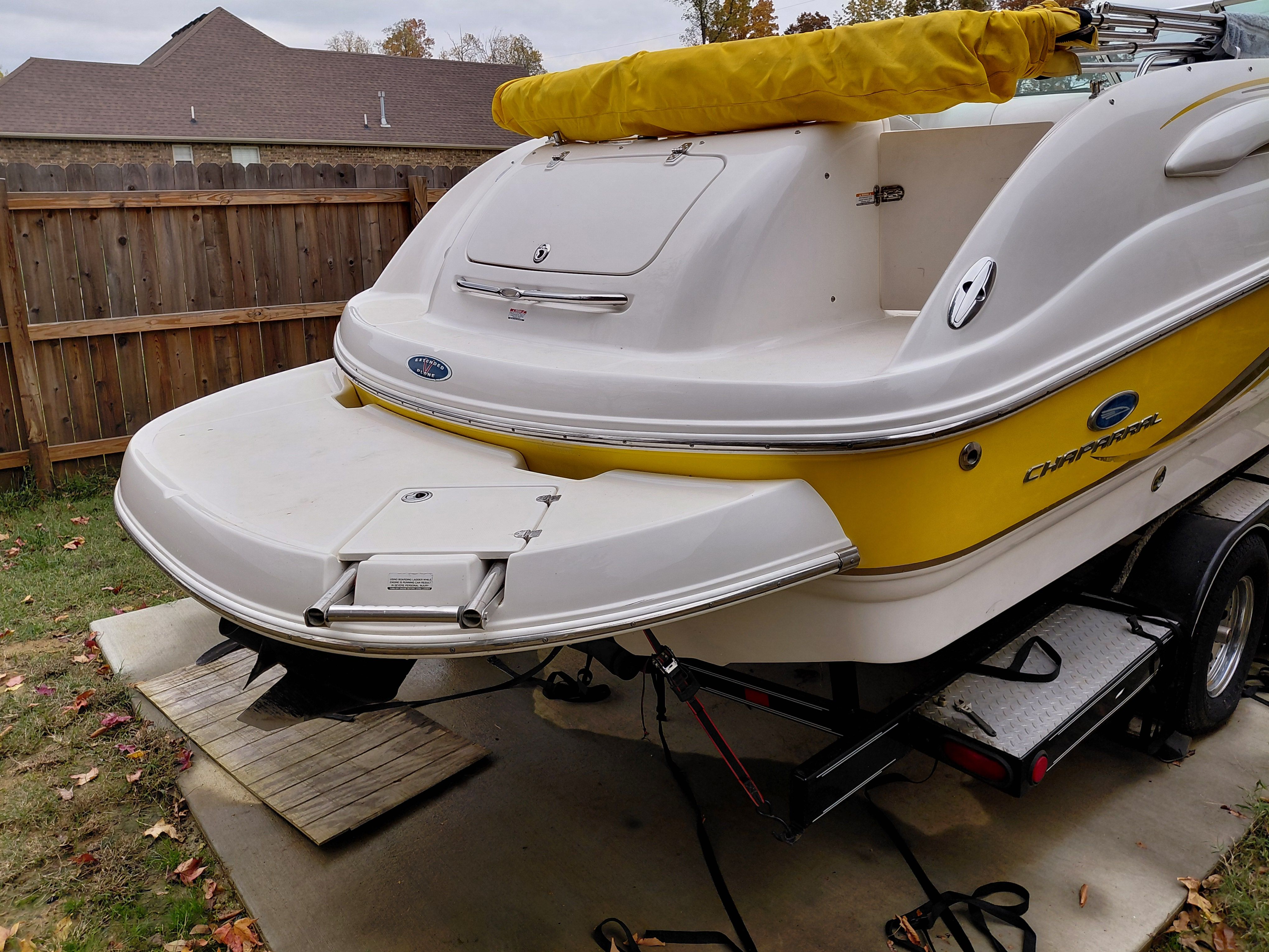 2005 Chaparral Sunestra 254 boat with yellow accent, parked on trailer.