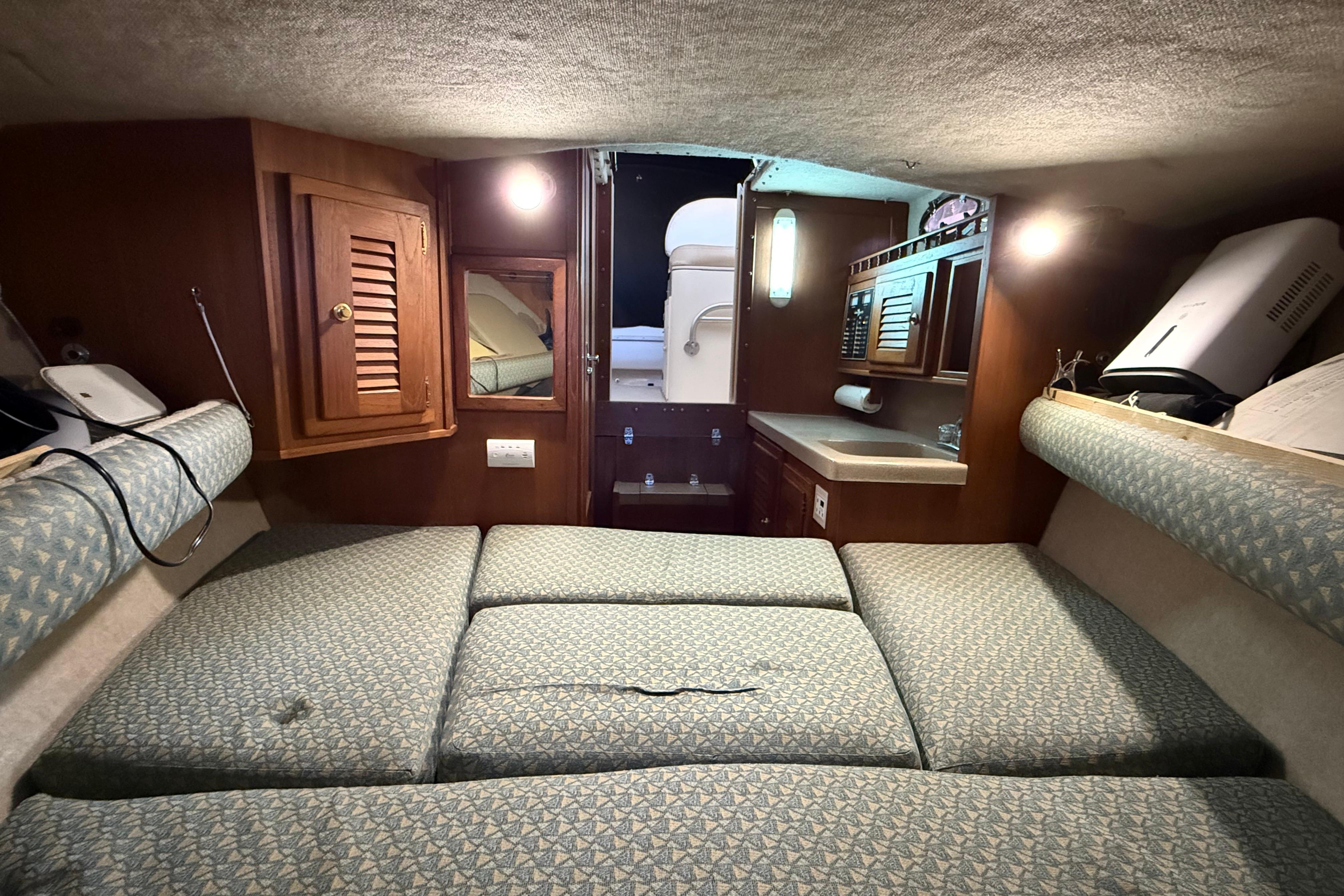 Interior cabin of 2002 Albemarle 265 Express Fisherman with cushioned seating and wooden cabinetry.