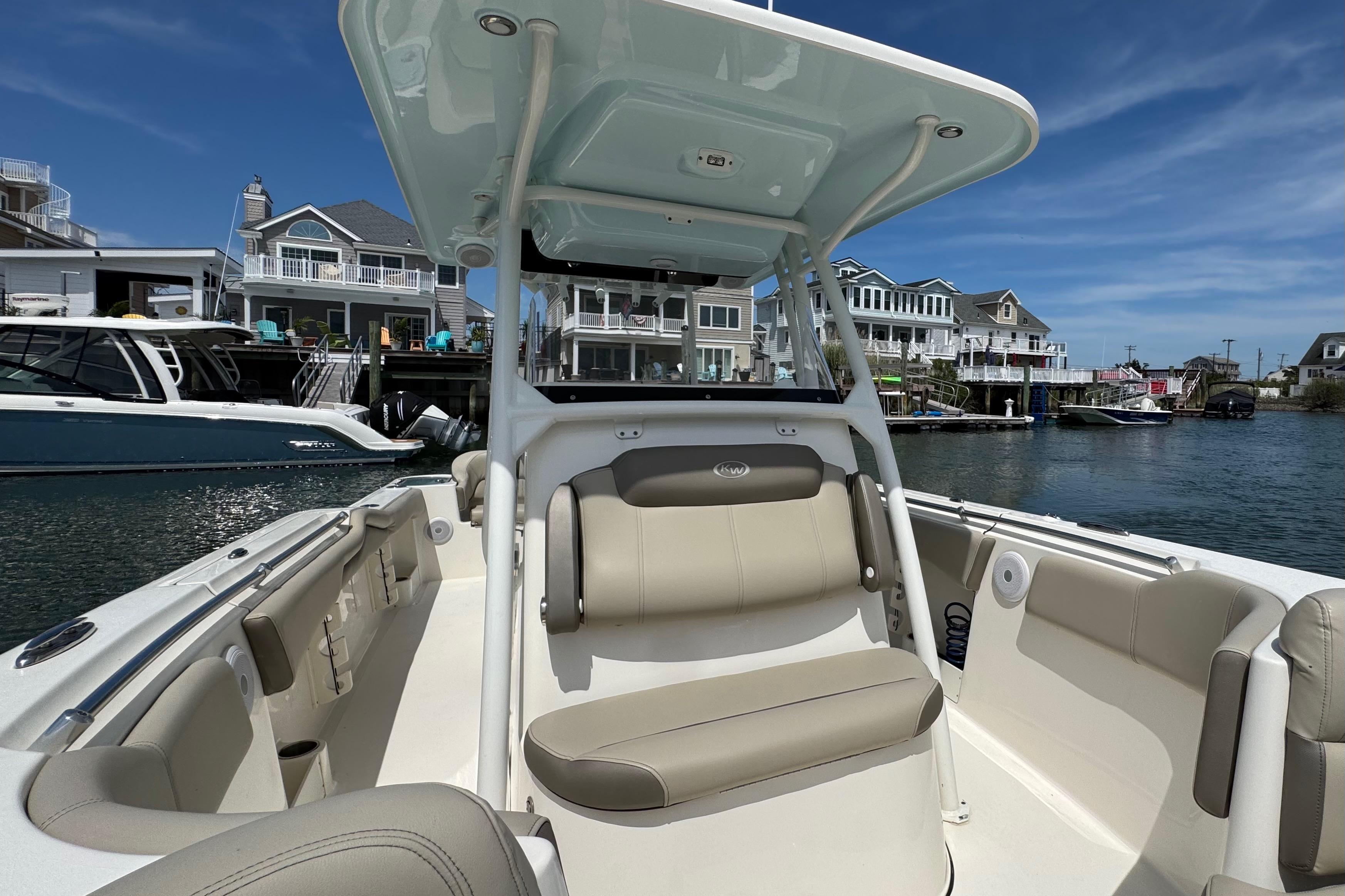 2022 Key West 263 FS boat interior with seating, docked near waterfront homes.