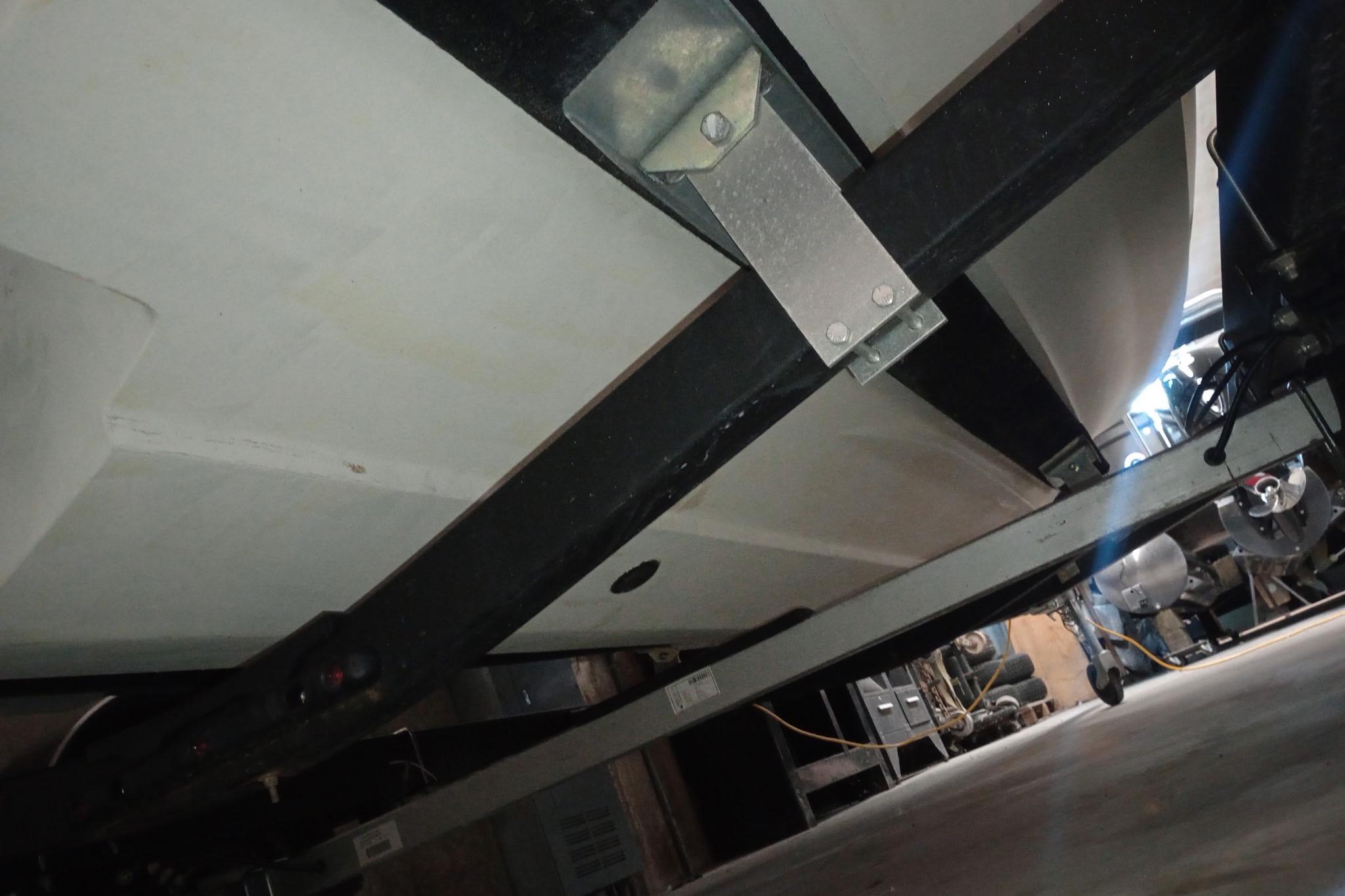 Underside view of 2022 Bayliner VR5 Bowrider I/O on a trailer in a garage.