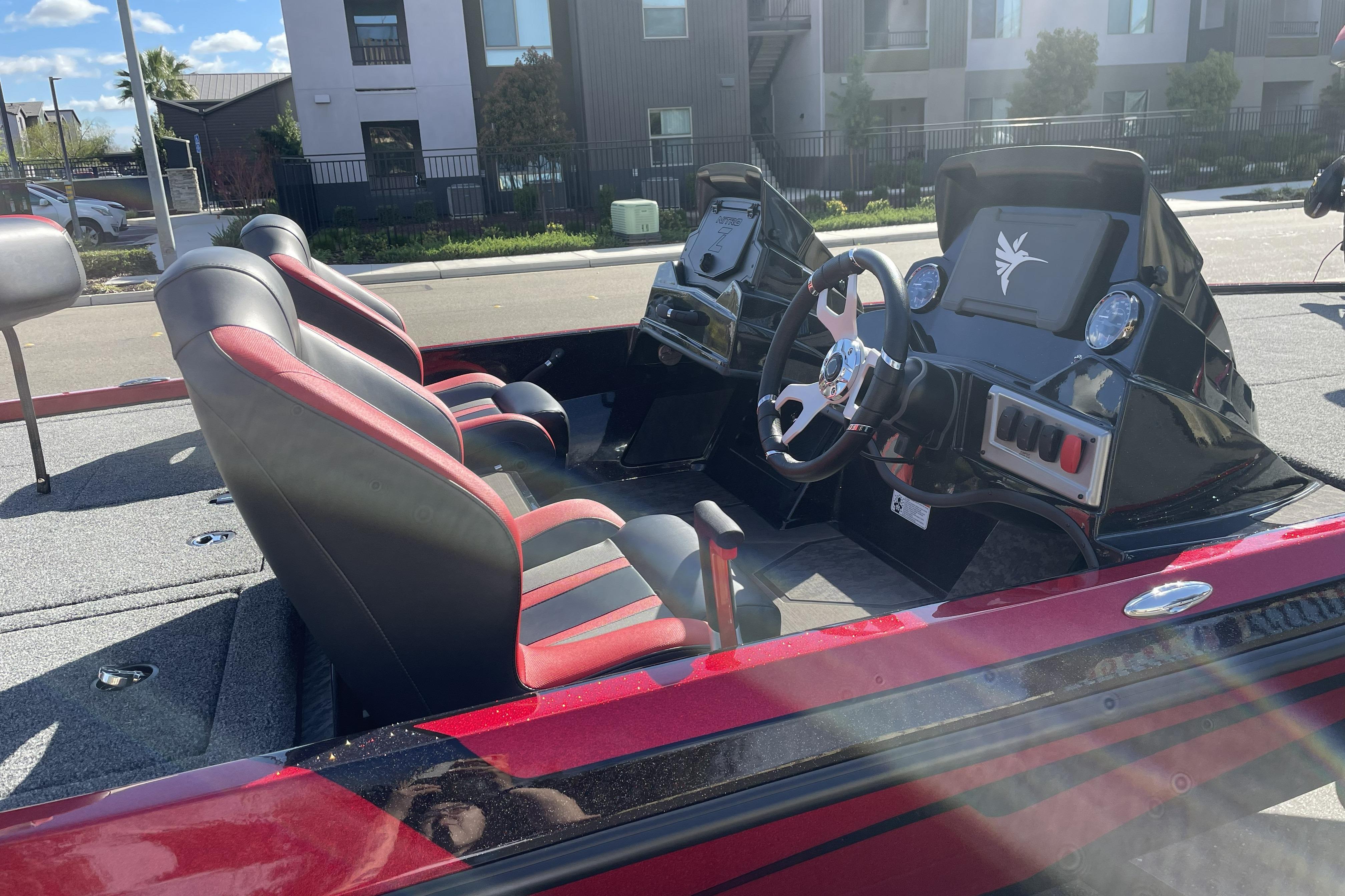 2026 Nitro Z19 XL boat interior with red and black seats, steering console, and modern design.