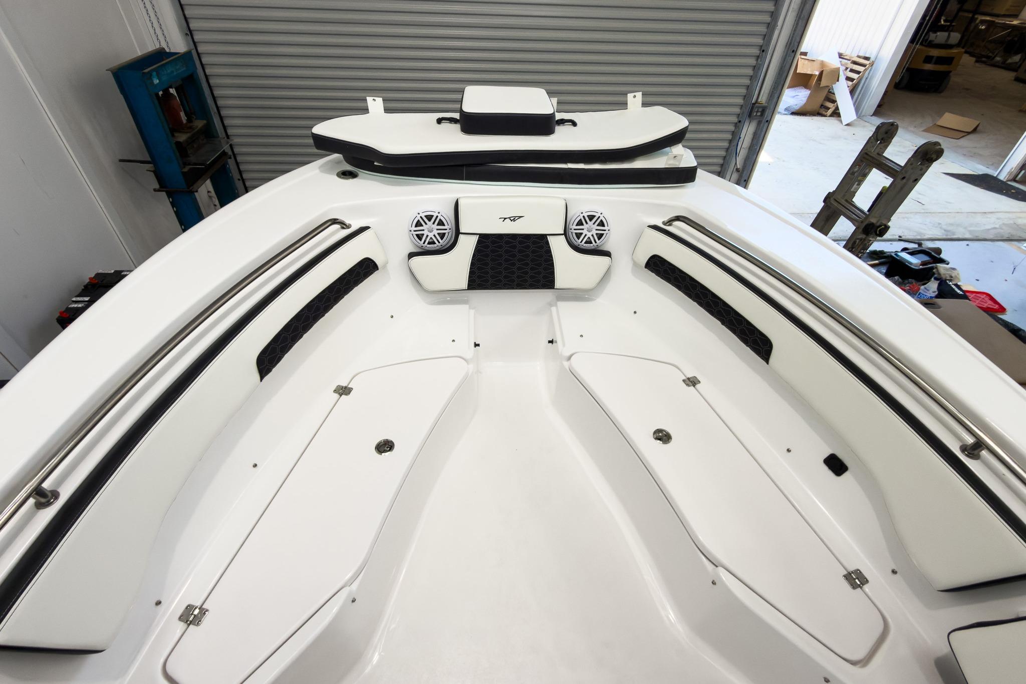 The image shows the bow of a Tidewater 220 LXF boat with white seating and speakers.