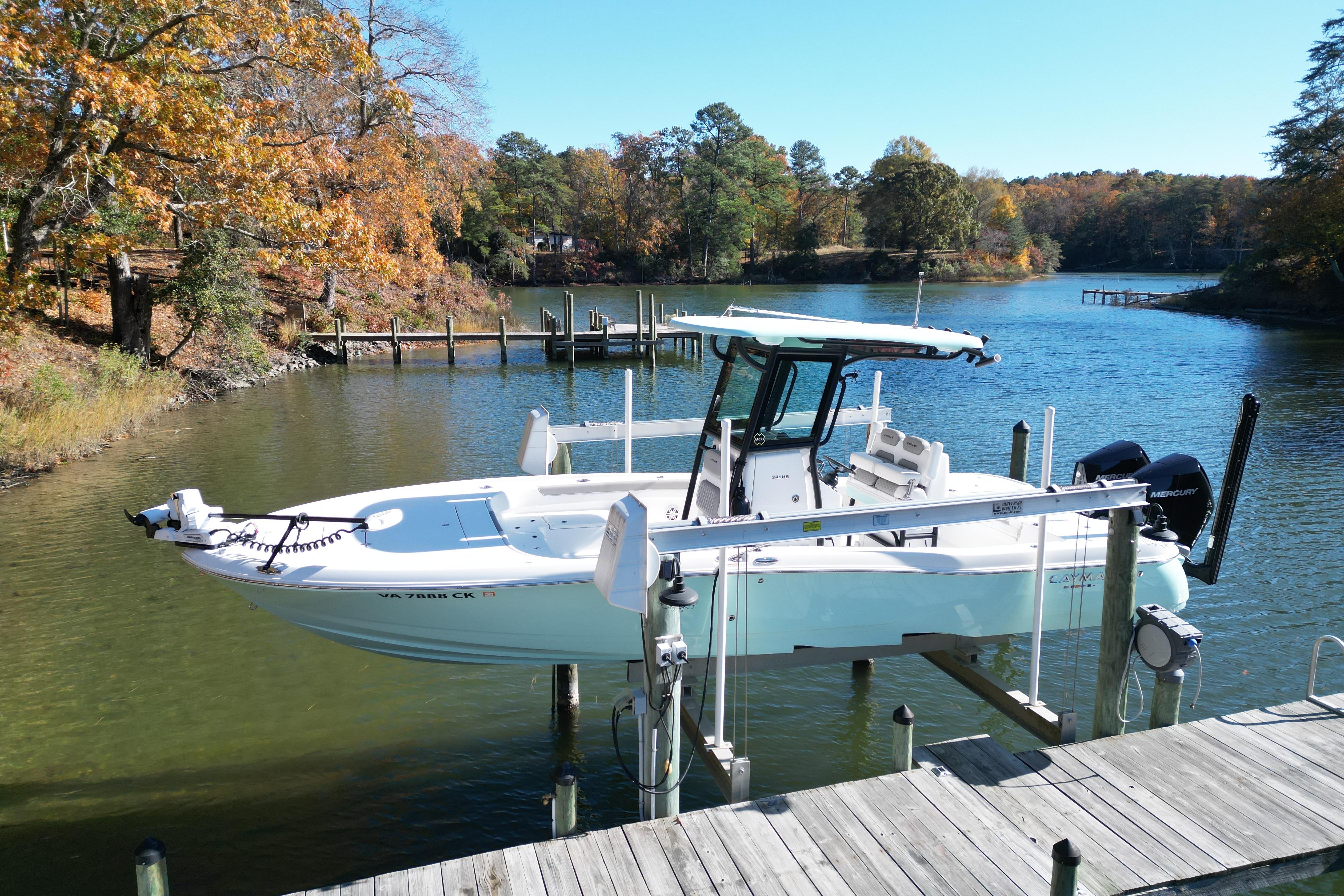 2023 Caymas 281 HB boat docked on a serene lake with autumn foliage.