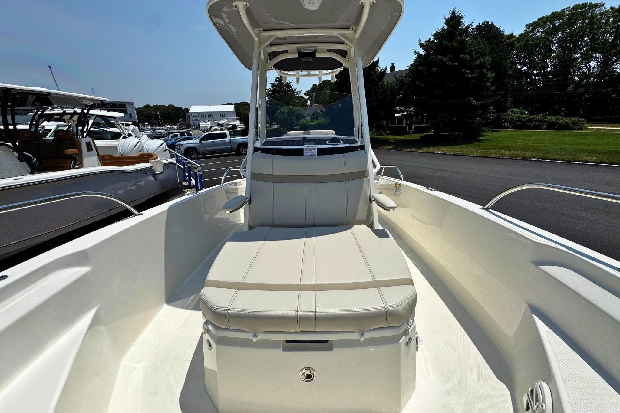 2026 Boston Whaler 220 Dauntless boat interior with seating and console, parked outdoors.