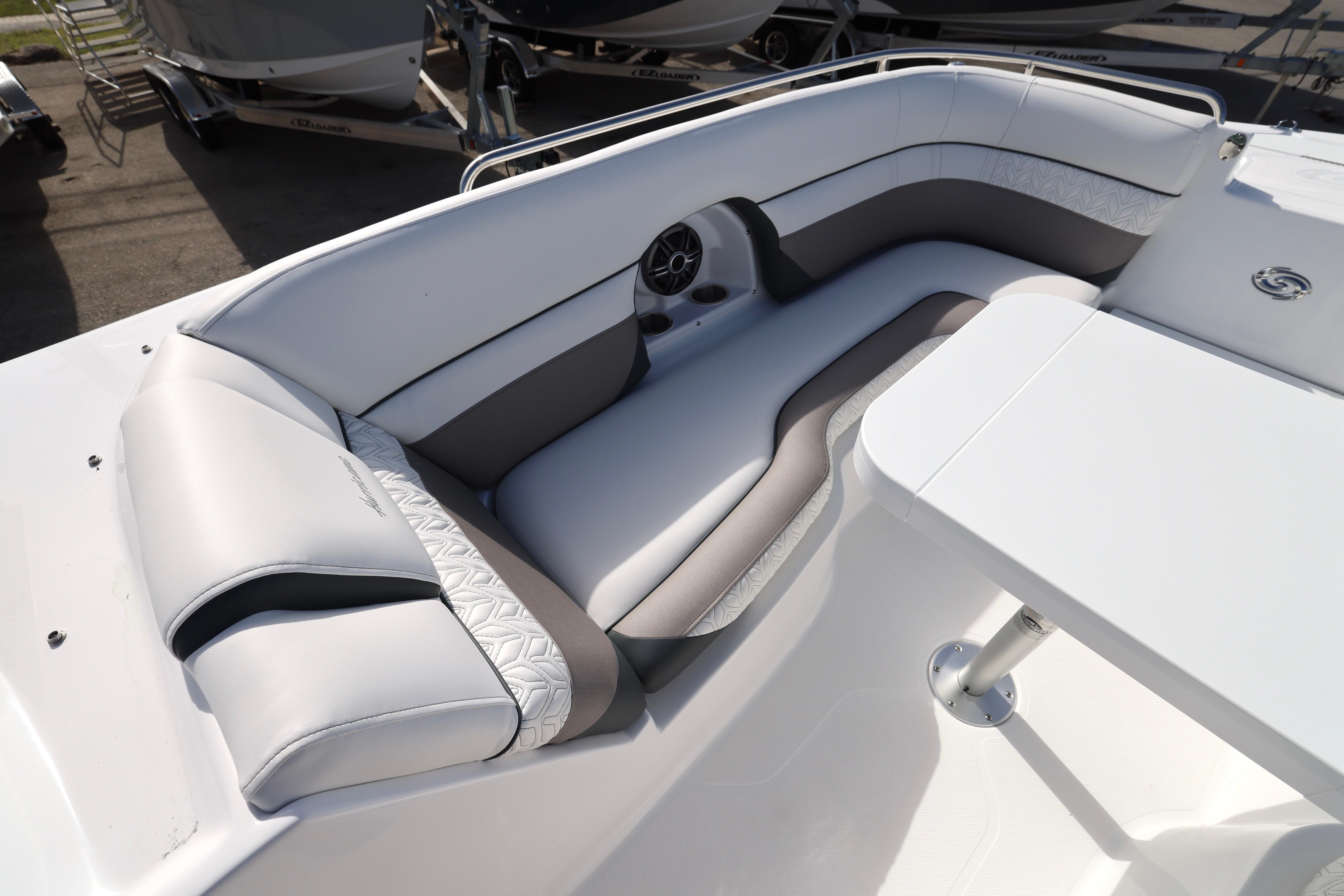 2026 Hurricane SunDeck 2486 OB boat interior with cushioned seating and table.