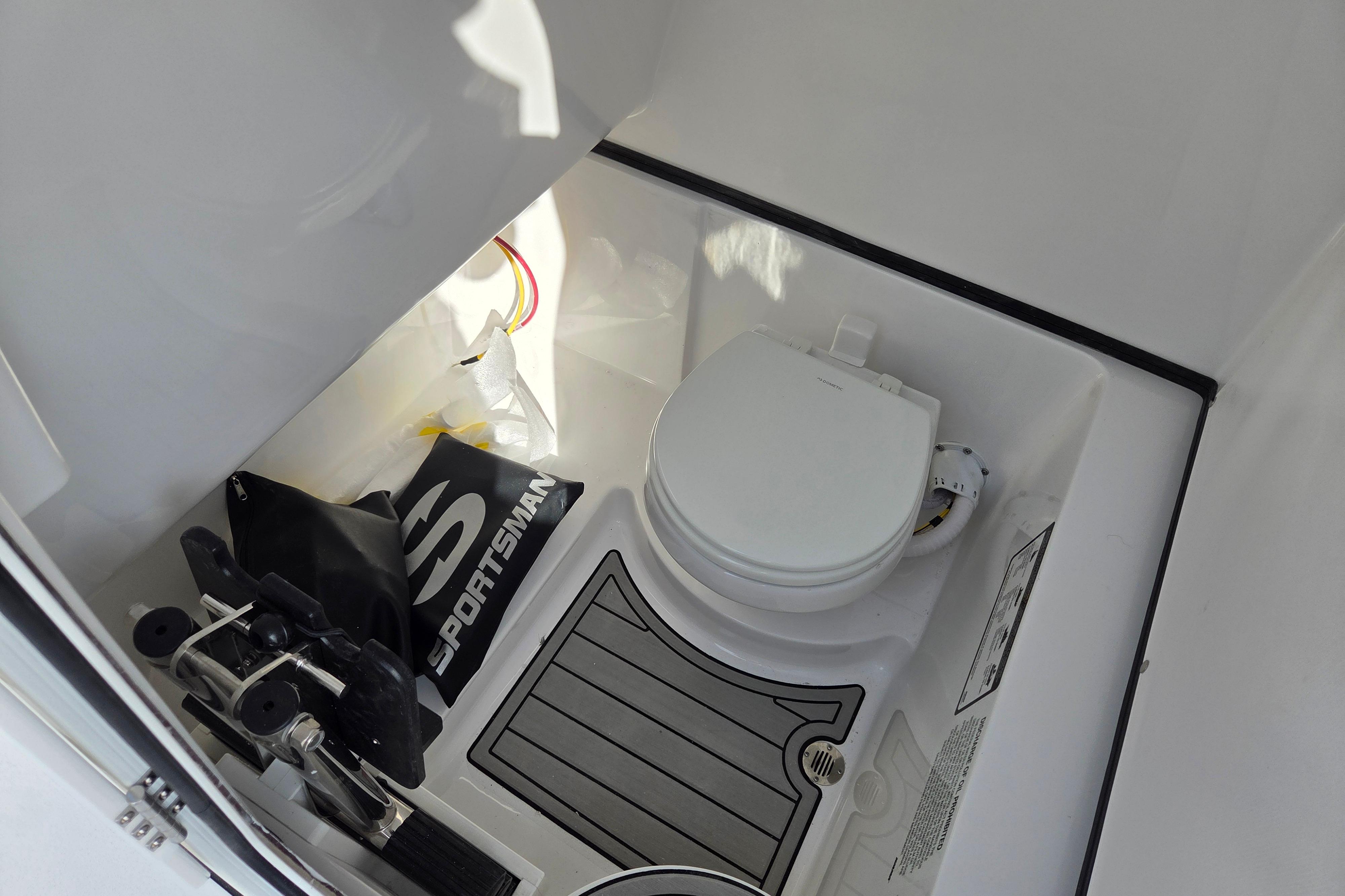 Interior of 2026 Sportsman Heritage 261 Center Console boat with toilet and storage area.