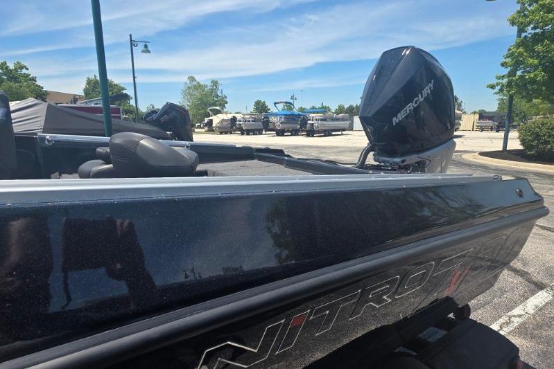 2026 Nitro ZV20 Pro boat with Mercury engine in parking lot under blue sky.
